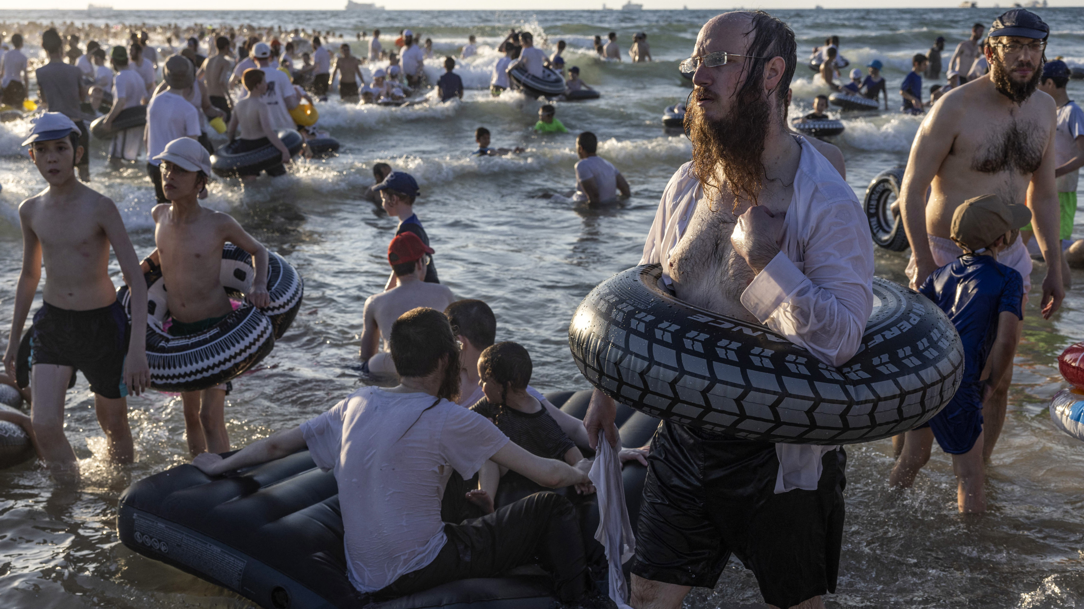 Des juifs ultra-orthodoxes sur une plage réservée exclusivement aux hommes sur la côte d’Ashdod, lors de congés pour les yeshivas, le 9 août 2023 (AFP)