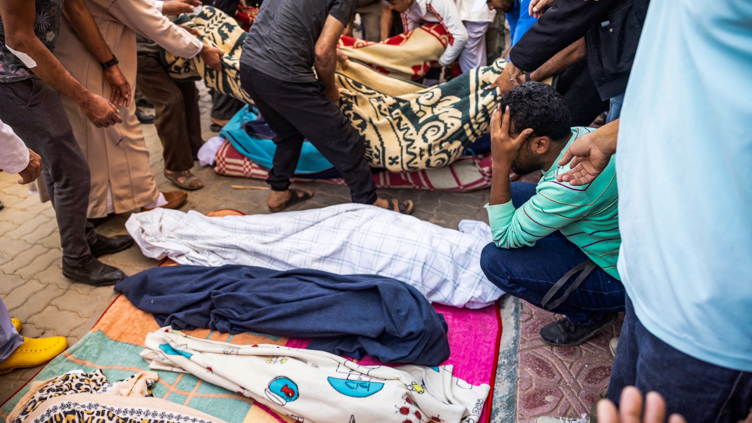 Relatives mourn in front of the bodies of the victims killed in an earthquake in Moulay Brahim village (AFP)