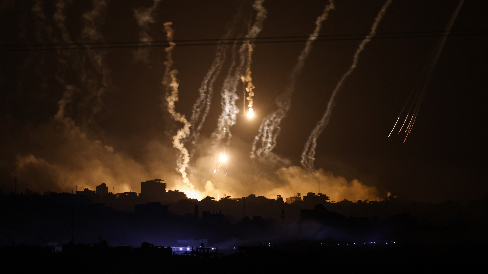 Smoke and flares dropped by Israeli forces over the Gaza Strip on 10 November 2023 (AFP)