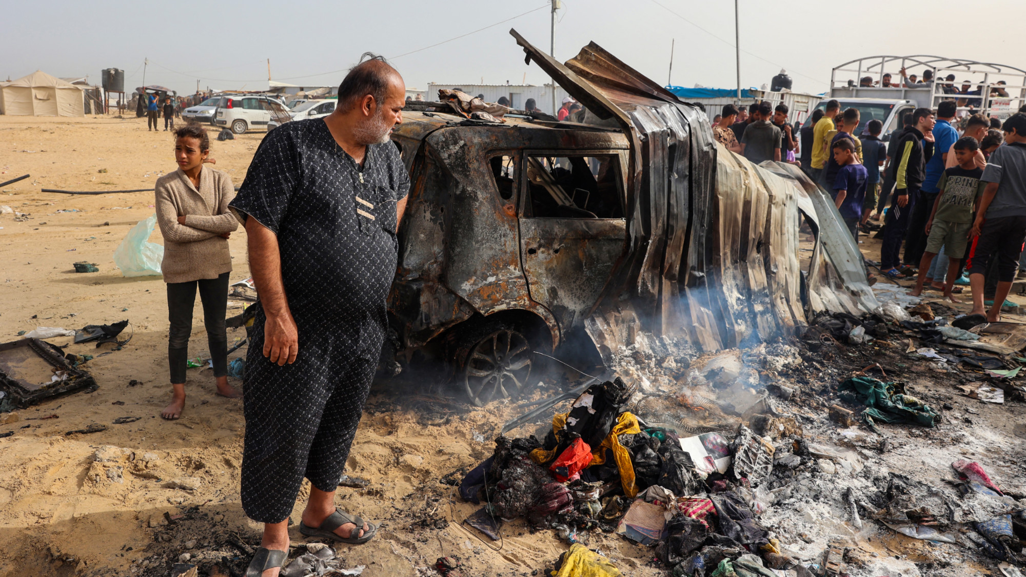 Des Palestiniens se rassemblent sur le site d’une frappe israélienne contre un camp de personnes déplacées à Rafah, le 27 mai 2024 (Eyad Baba/AFP)