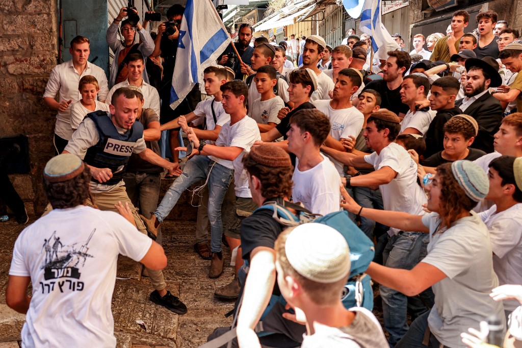 Israeli right-wing activists scuffle with Palestinian freelance journalist Saif Kwasmi on 5 June 2024 during the so-called Jerusalem Day flag march (Hazem Bader/AFP)