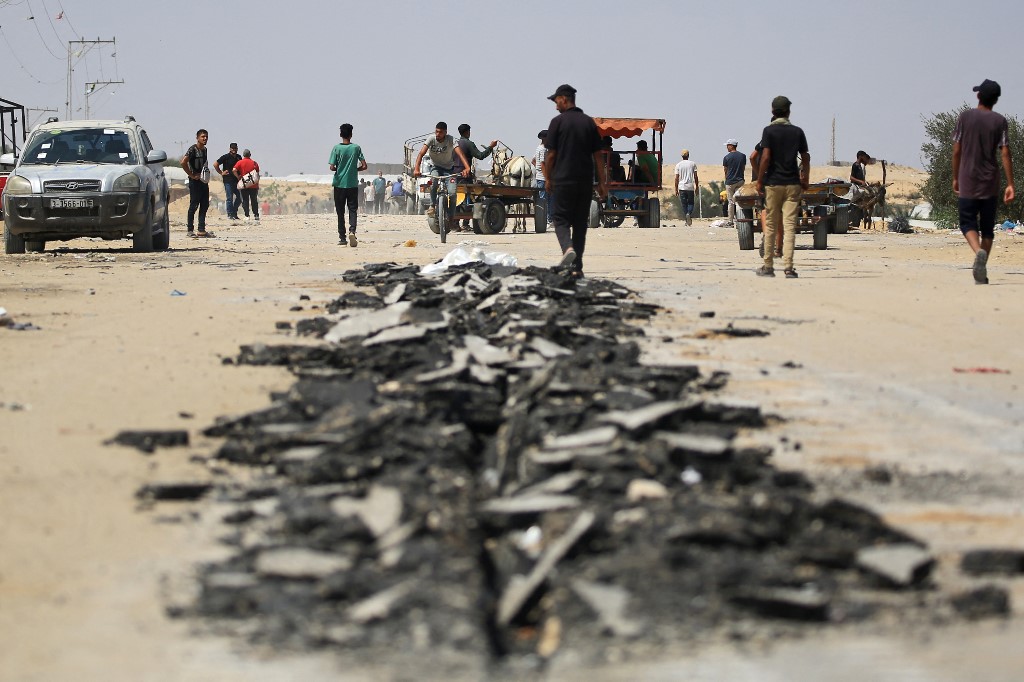 Palestinians flee western Rafah on June 29, 2024, on a road damaged by Israeli buldozers during a raid on al-Mawasi area,