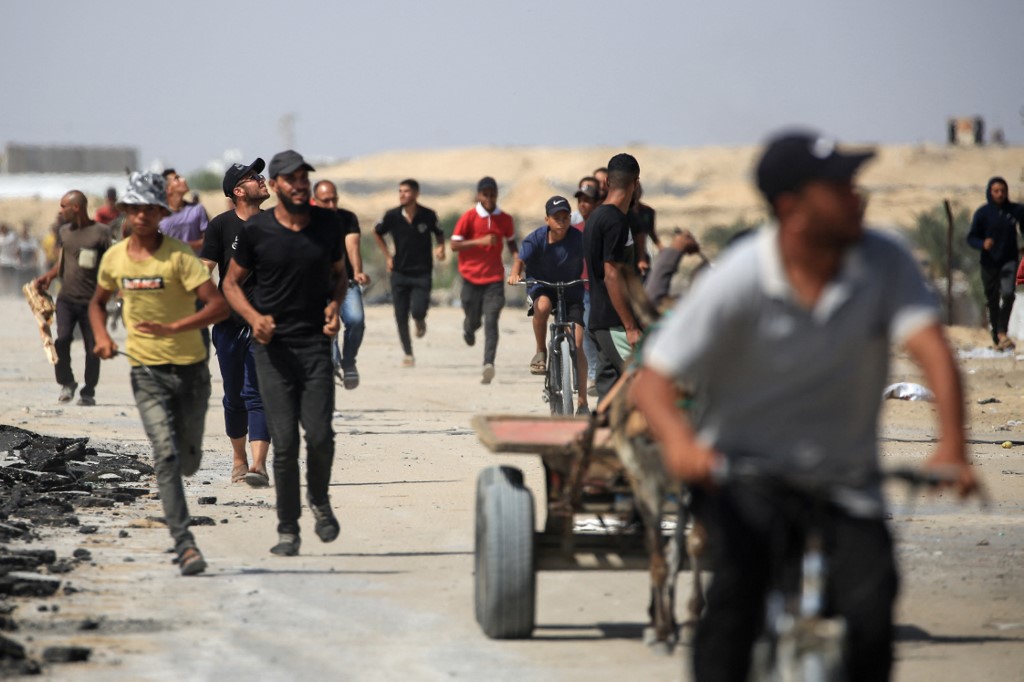 People run for cover during a Israeli drone attack as Palestinians flee al-Mawasi area in western Rafah on June 29, 2024