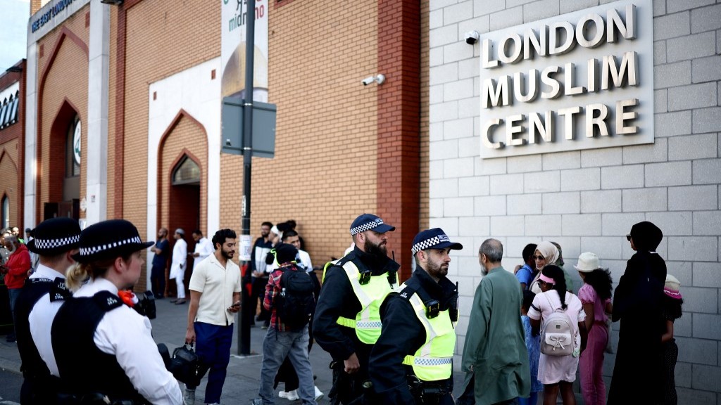 Police officers stand guard outside the East London Mosque after Friday prayers in Tower Hamlets in London on 9 August (AFP)