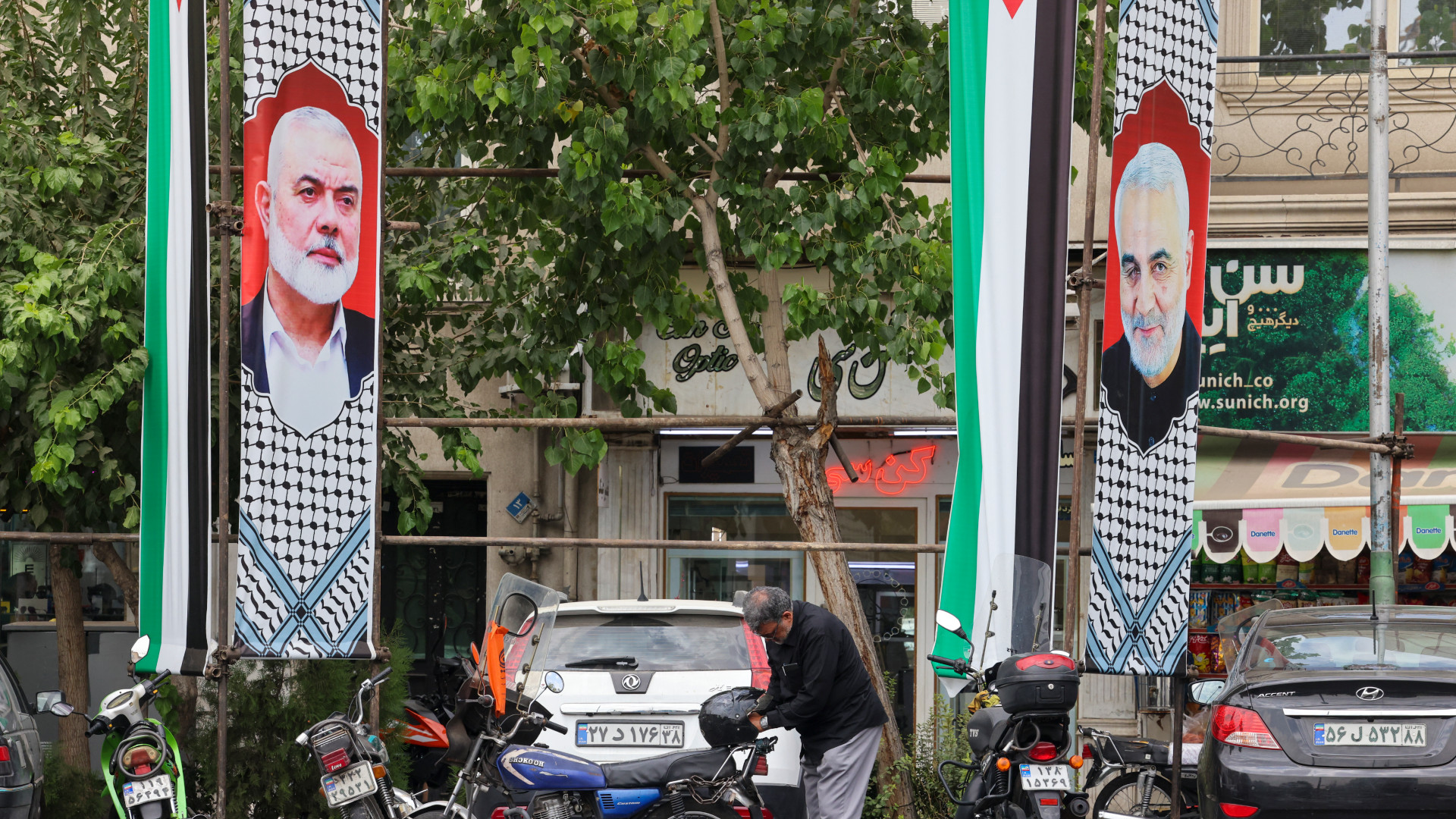 Banners depicting Hamas leader Ismail Haniyeh and Iranian commander Qassem Soleimani are pictured near Palestine Square in Tehran, on 12 August (Atta Kenare/AFP)