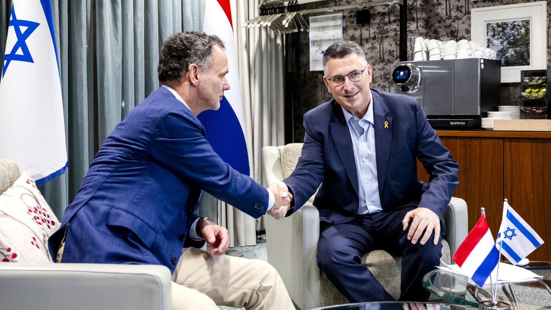 Dutch Foreign Minister Caspar Veldkamp, left, shakes hands with Israel's Foreign Minister Gideon Saar during their meeting in Amsterdam on 9 November 2024, following tensions and violence involving Israeli football fans during the Uefa Europa League match last week (Sem van der Wal/ANP/AFP)