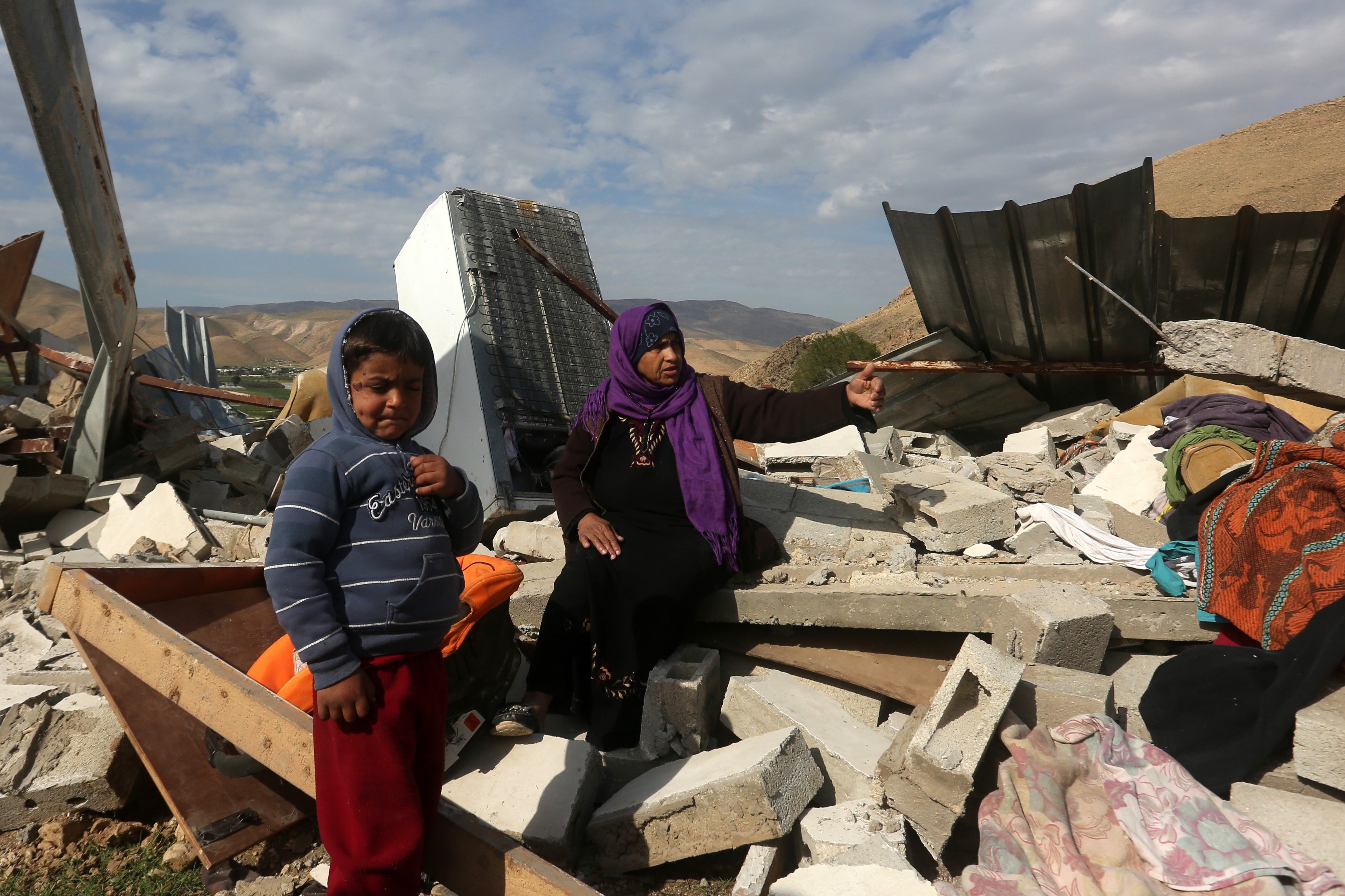 Palestinians check the rubble of their house after it was demolished by Israeli authorities in the West Bank village of Jeftlek