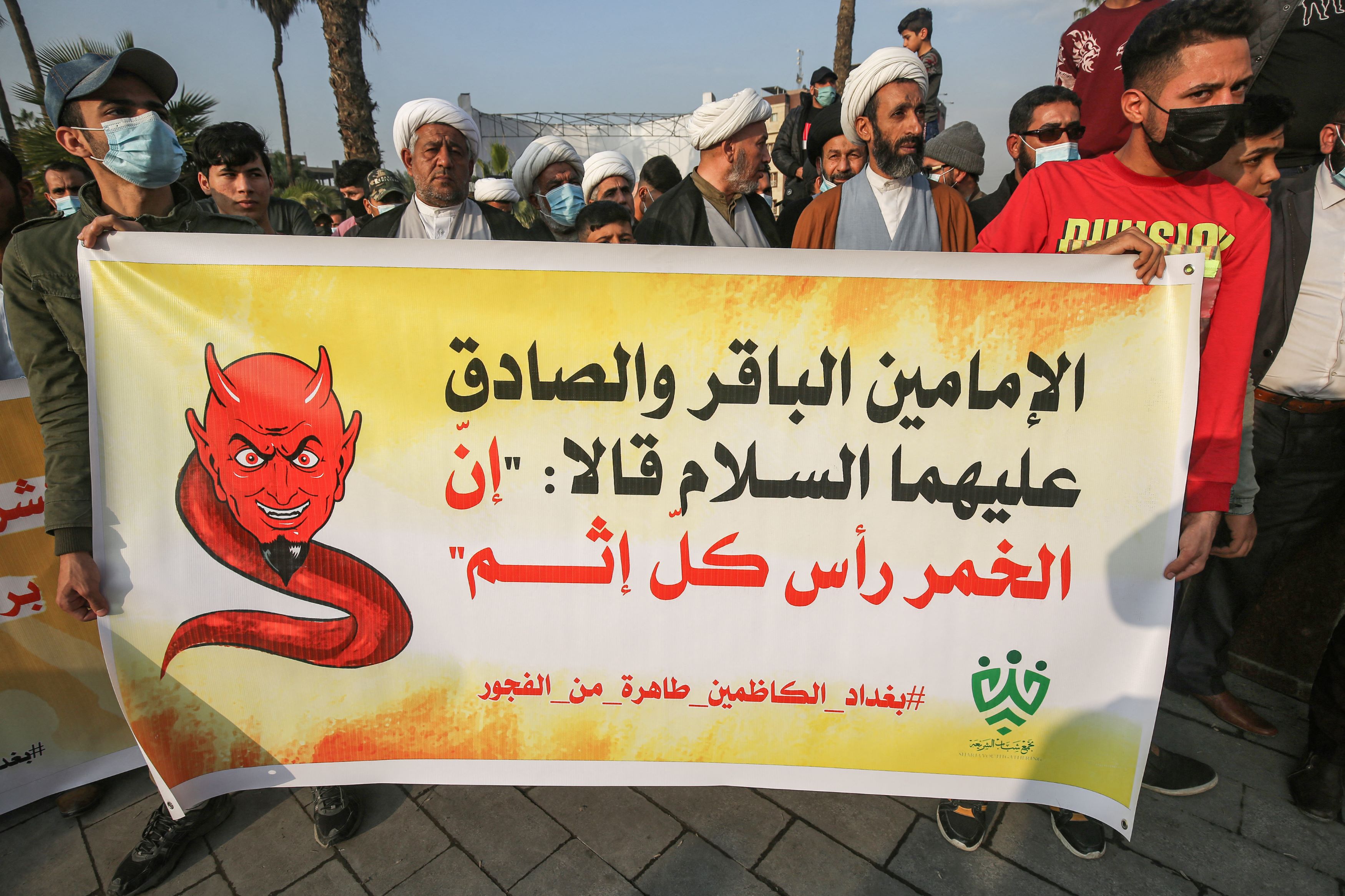 Shia Muslim clerics  march with a banner quoting Imams Baqir and Sadiq as saying that alcohol is the root of all sin, during a demonstration in Iraq's capital Baghdad (AFP)