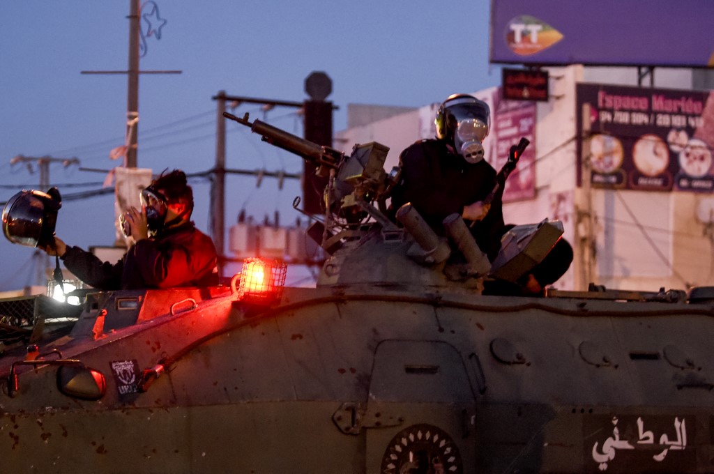 Members of the Tunisian National Guard seated in their armoured vehicles in Ettadhamen on 17 January 2021 (AFP)