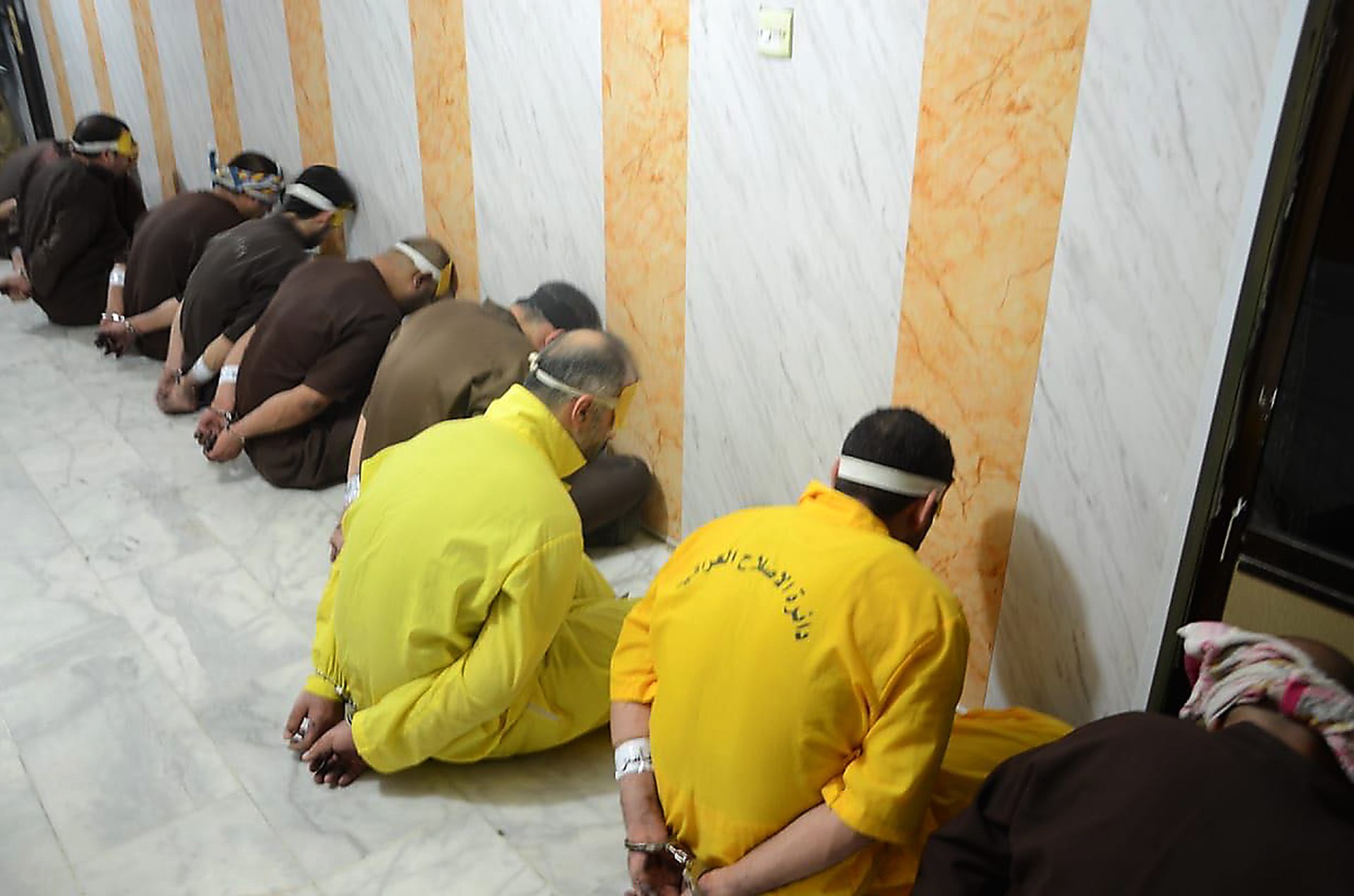 Blindfolded and handcuffed Islamic State militants who have been condemned to death waiting for their sentences to be executed (AFP)