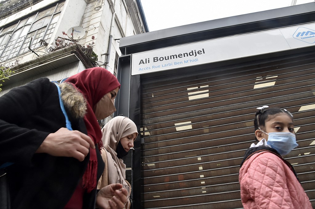 Algerian women walk in front of an Algiers metro station, still shuttered due to the pandemic (AFP/Ryad Kramdi)