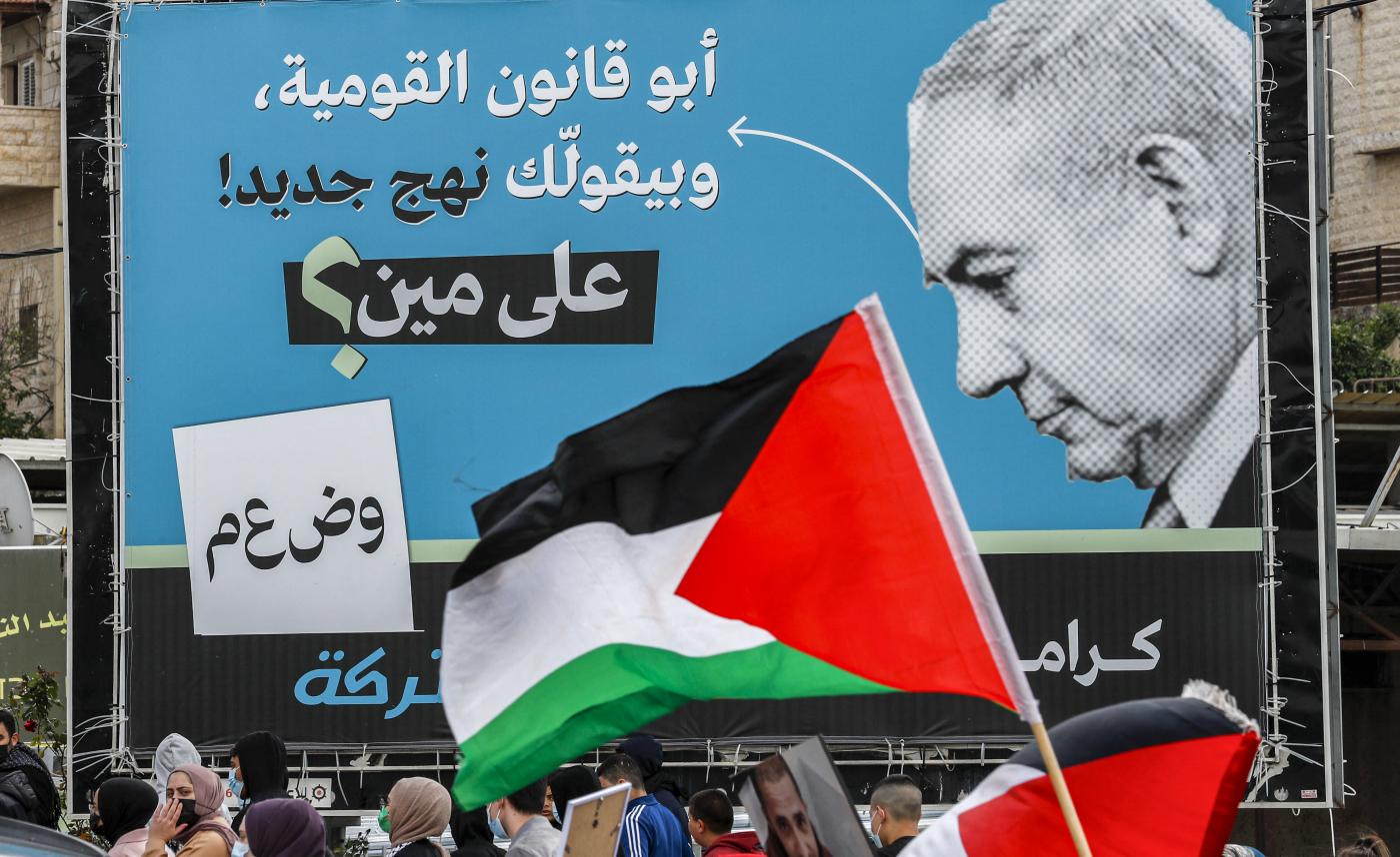 An electoral billboard by the Joint List depicting Premier Benjamin Netanyahu with a caption in Arabic saying "the father of the nation-state law, says 'a new approach', who is he fooling?", in Umm al-Fahm on 12 March 2021 (AFP)