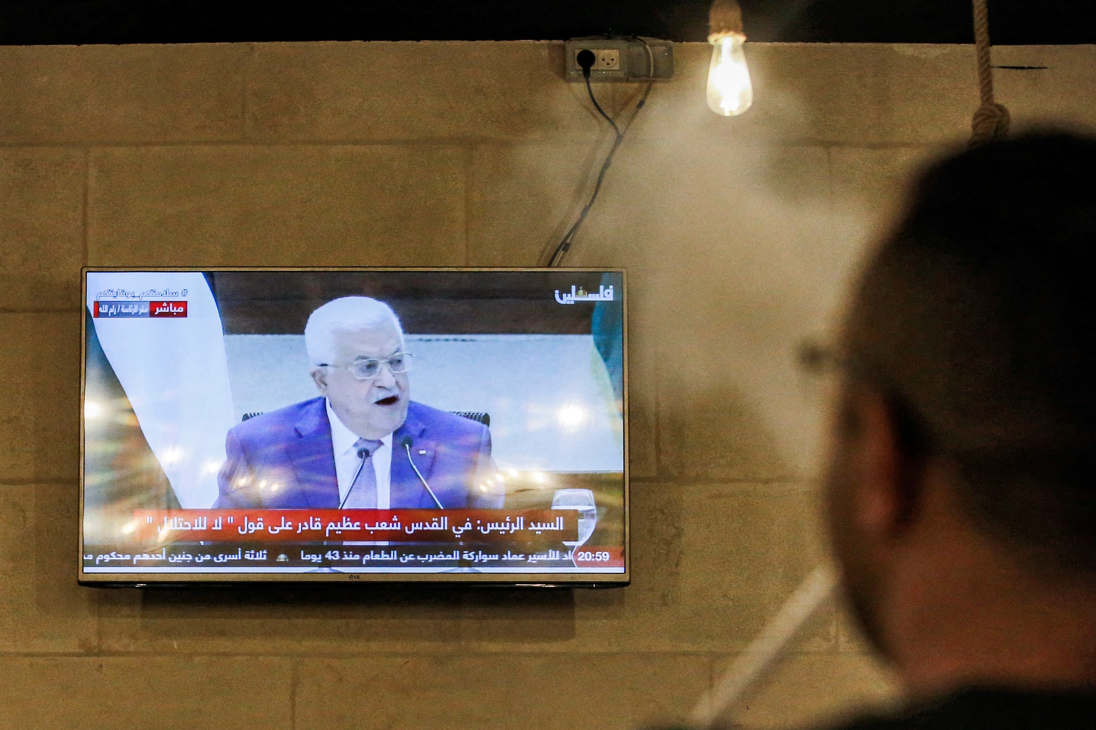 People watch a televised speech by Palestinian president Mahmud Abbas regarding the upcoming Palestinian elections at a coffee shop in the city of Hebron in the occupied West Bank on April 29, 2021.