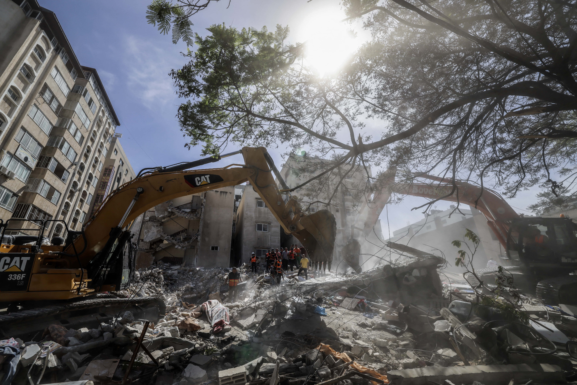 An excavator clears the rubble of a destroyed building in Gaza City's Rimal residential district on 16 May, 2021, after an Israeli air strike (AFP)