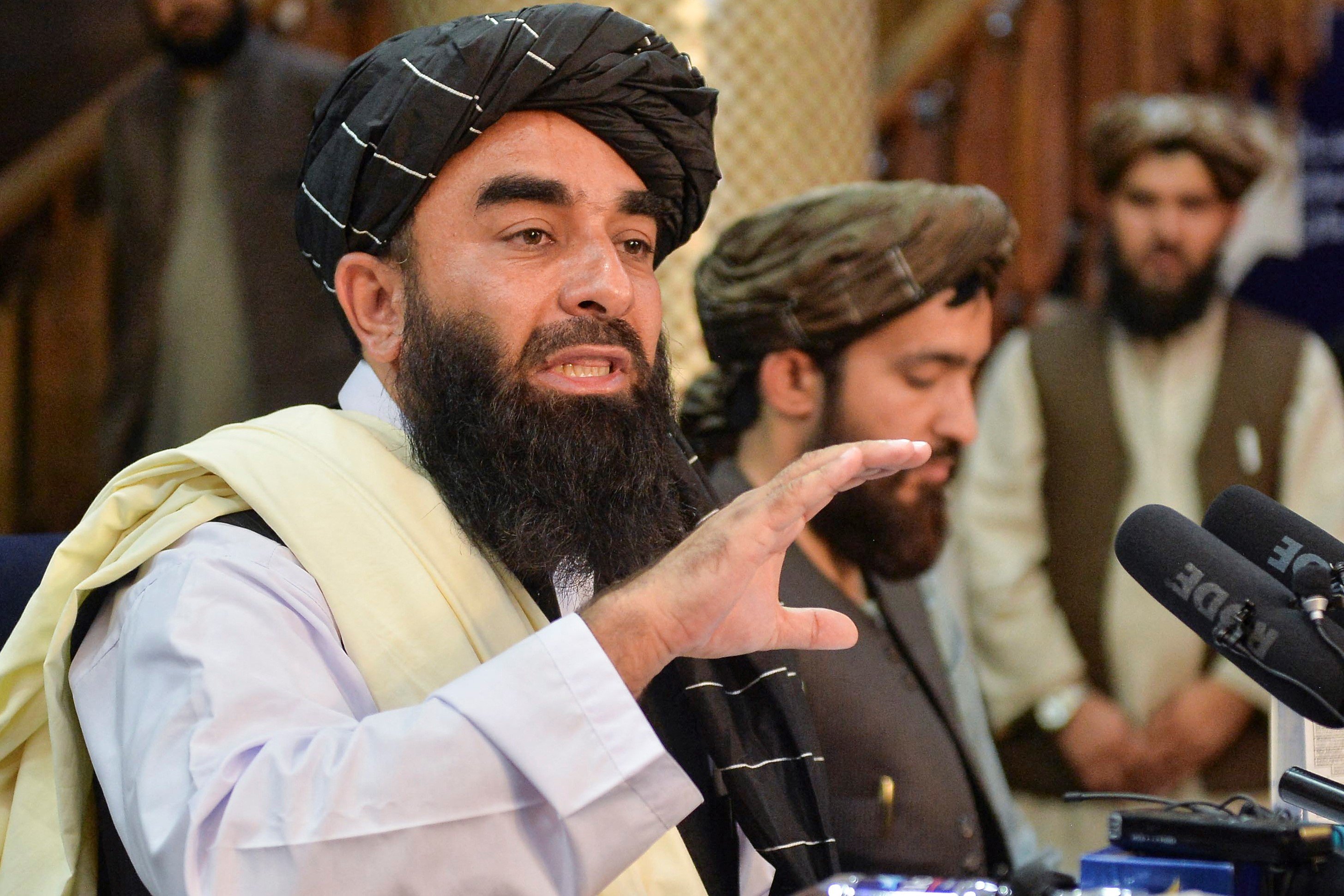 Zabihullah Mujahid (à gauche), porte-parole des talibans, lors de leur première conférence de presse à Kaboul, le 17 août 2021 (AFP)