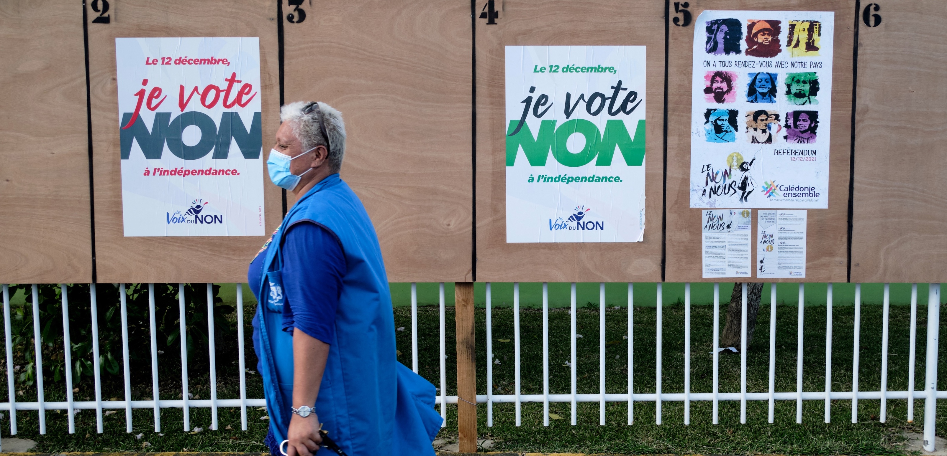 A woman walks past electoral boards near a polling station ahead of the referendum on independence in Noumea, on the French South Pacific territory of New Caledonia, on December 10, 2021.