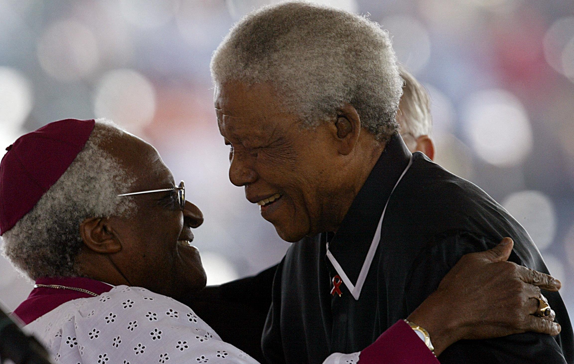 his file photo taken on May 17, 2003 Former South African President Nelson Mandela (R) hugs South African Anglican Bishop Desmond Tutu