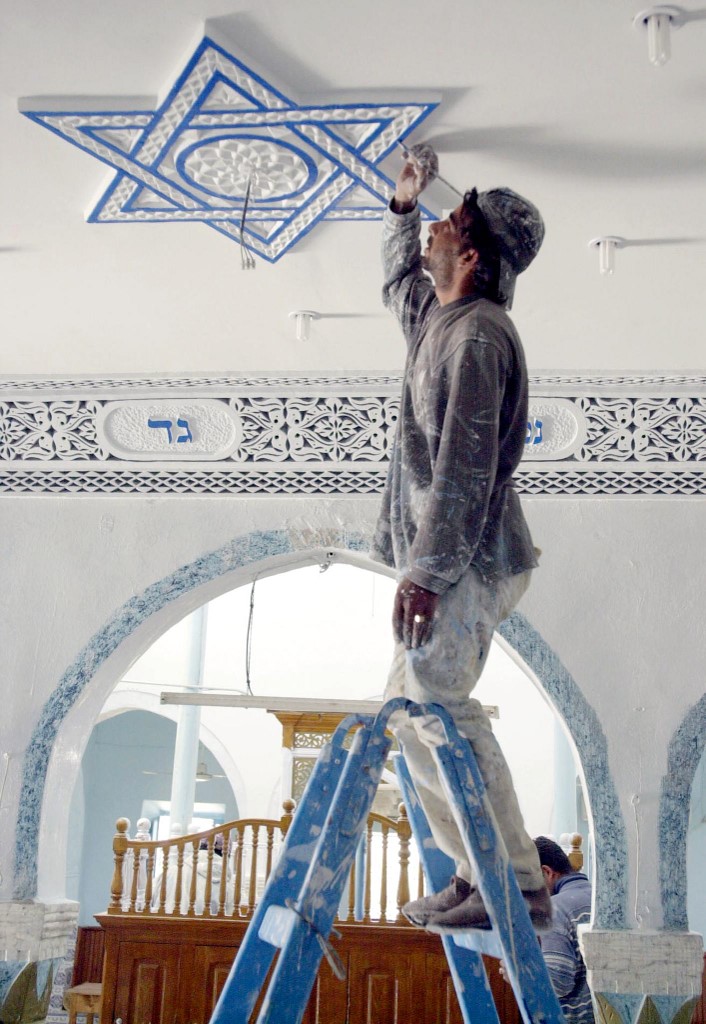 Un peintre décore l'étoile de David sur le plafond de la synagogue, à Djerba, en Tunisie (AFP)