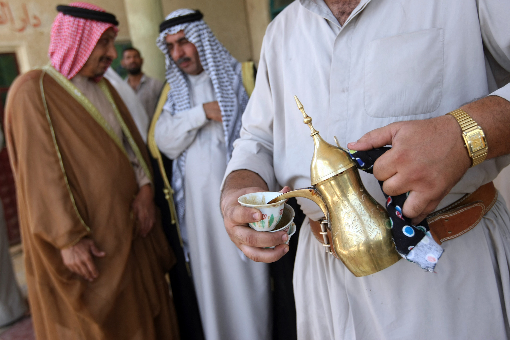 Arabic coffee is poured from a gold Dallah (AFP/ Ahmad al-Rabaye)