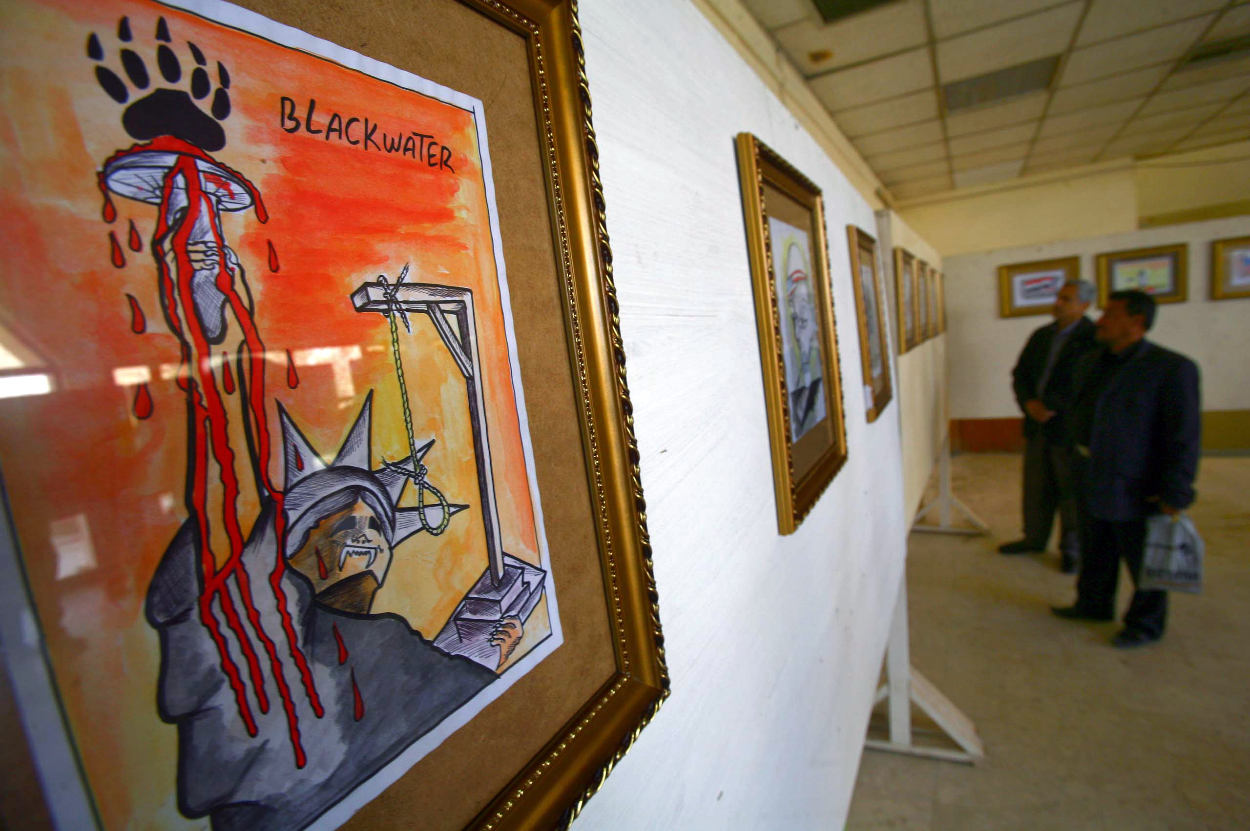 A cartoon against US security firm Blackwater, which was barred from Iraq over the deadly 2007 shooting, is displayed at an exhibition in Karbala, central Iraq in 2011 (AFP)