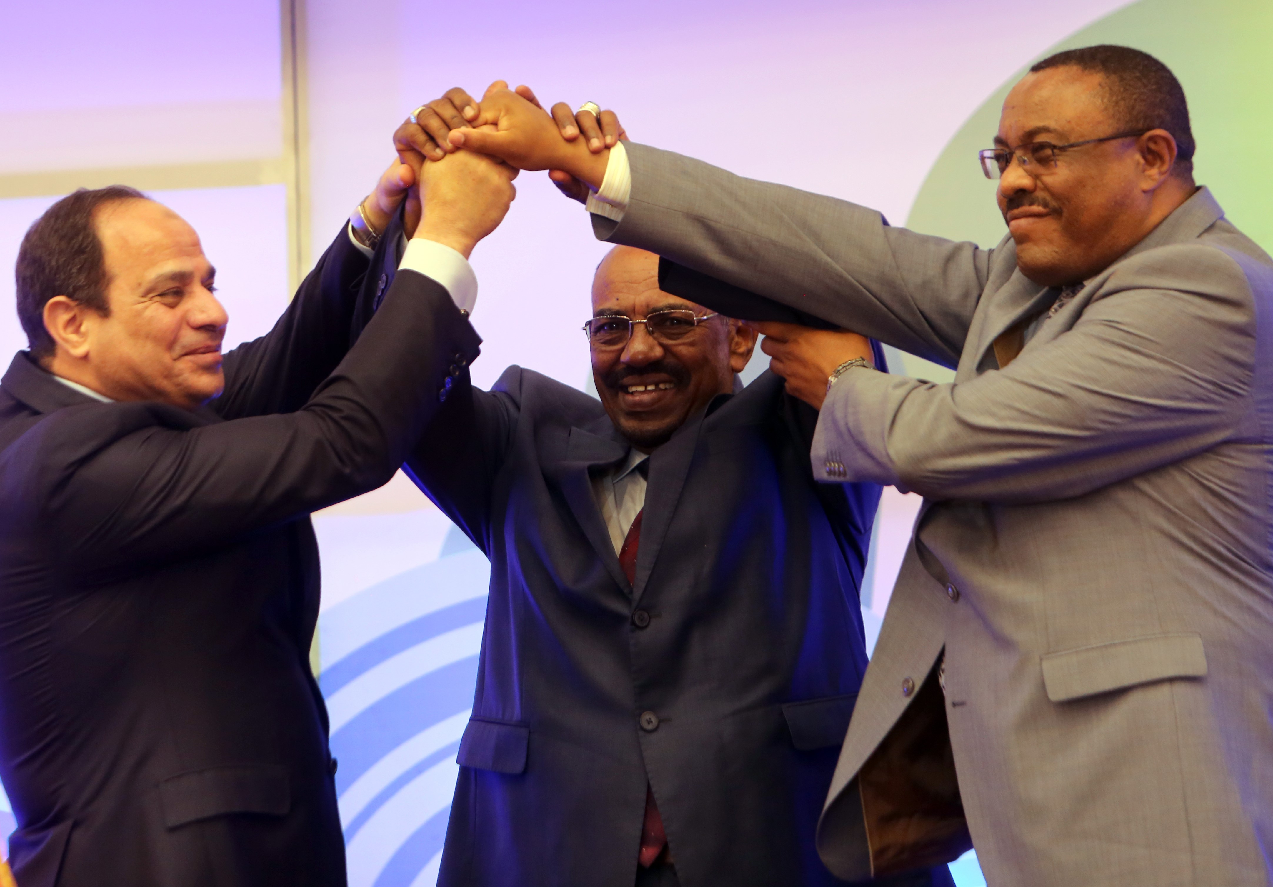 Egyptian President Abdel-Fattah al-Sisi (L), Sudanese President Omar al-Bashir (C) and Ethiopian Prime Minister Hailemariam Desalegn shake hands during a meeting in the Sudanese capital Khartoum on March 23, 2015, to sign the agreement of principles on Ethiopia's Grand Renaissance dam project