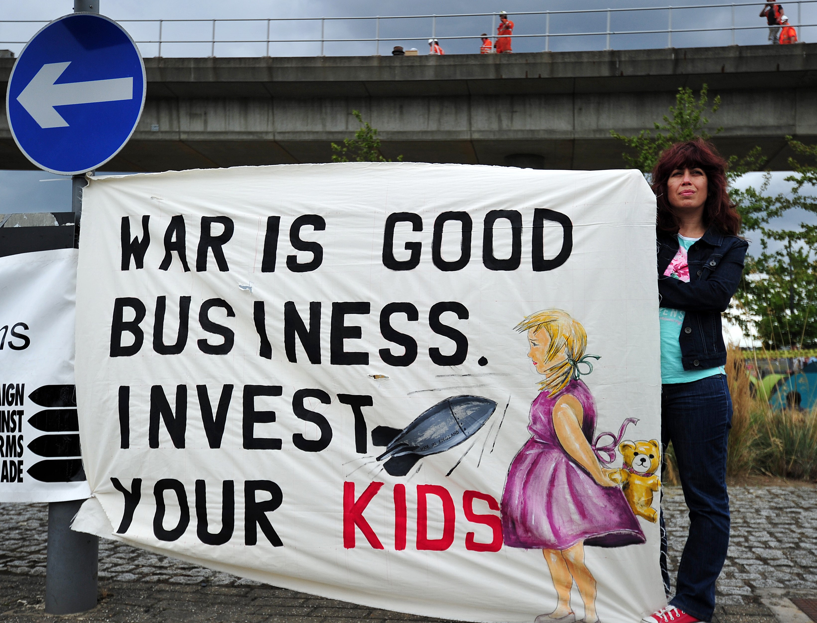 A protester holds a banner during a demonstration against the arms fair (AFP)