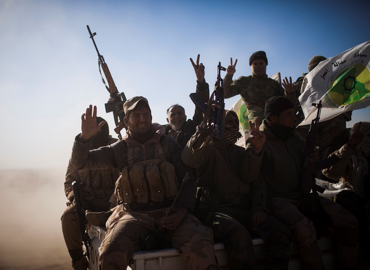 Des combattants des Hachd al-Chaabi font le signe de la victoire dans la région de Tall Afar, le 20 novembre 2016, dans le cadre de la bataille contre l’EI en Irak (AFP)