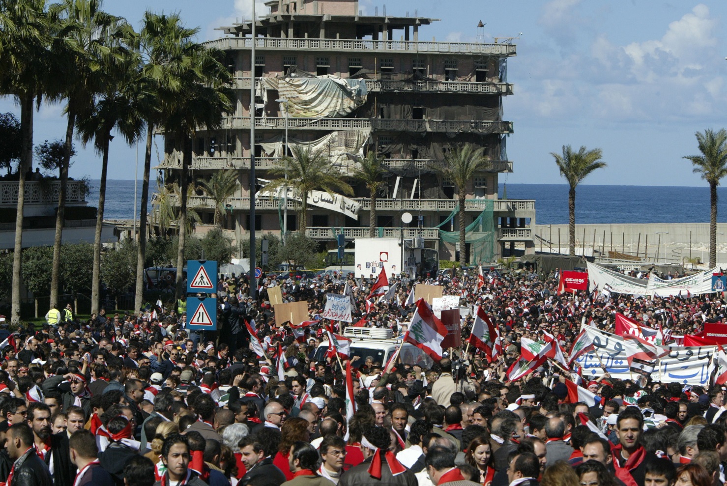 Des milliers de Libanais manifestent le 21 février 2005 sur le site de l’assassinat de l’ancien Premier ministre Rafiq Hariri, le 14 février, dans le centre de Beyrouth. L’hôtel Saint-George, détruit pendant la guerre civile, est visible à l’arrière-plan (AFP)