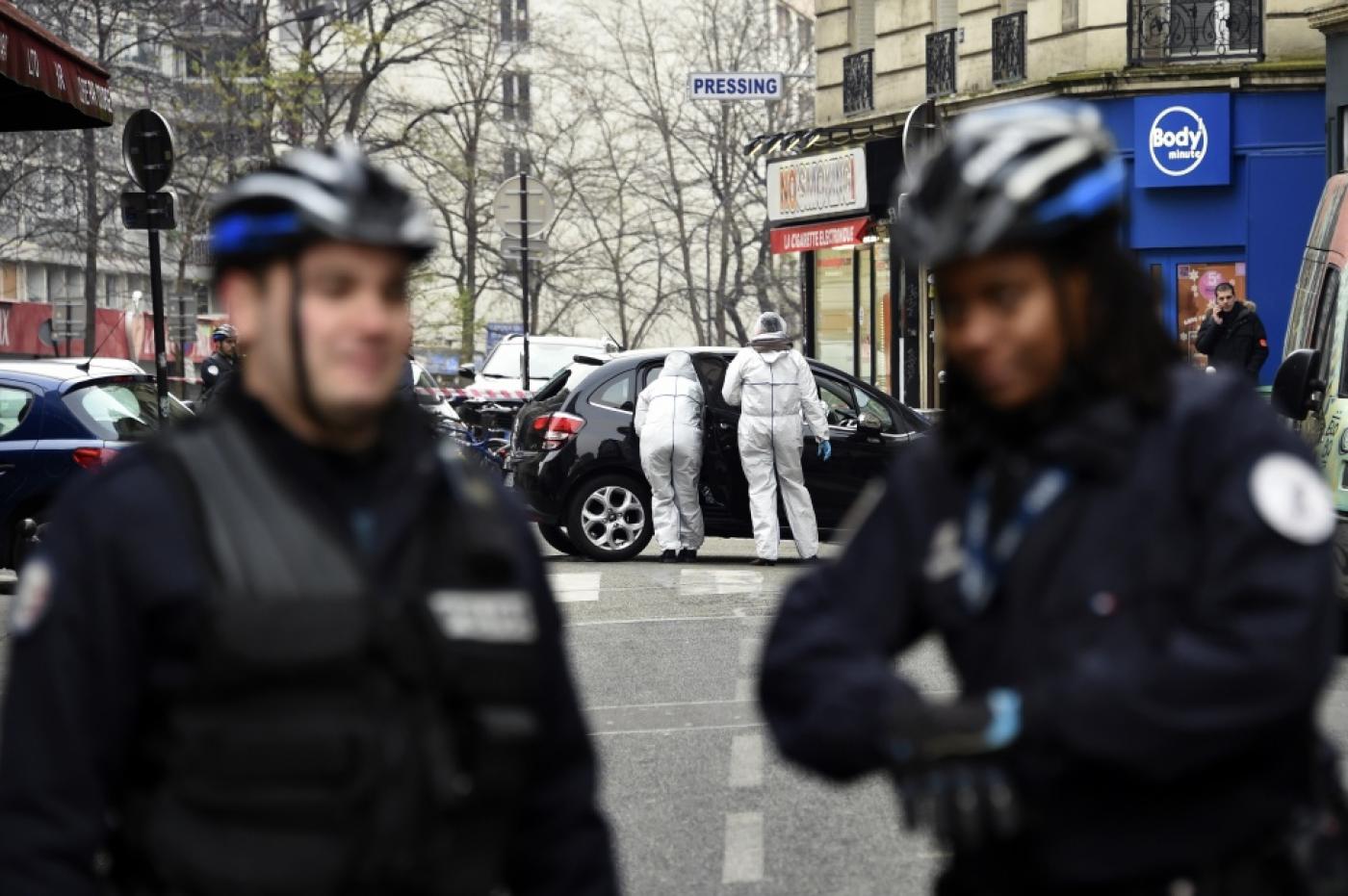 Des officiers de police et des experts en médecine légale examinent la voiture utilisée par des hommes armés qui ont pris d’assaut les locaux parisiens du journal satirique Charlie Hebdo, tuant douze personnes, le 7 janvier 2015 (AFP)