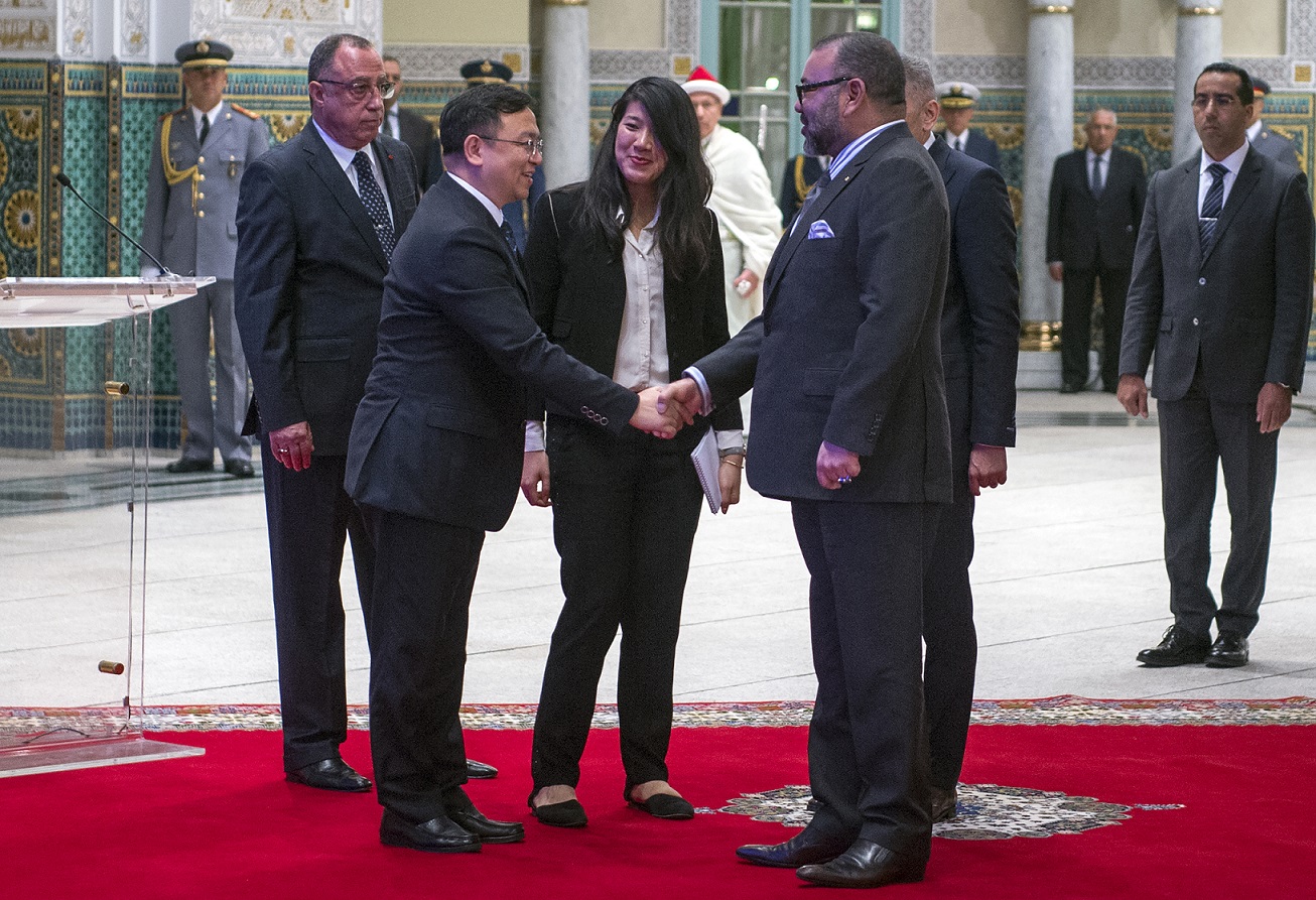 Le roi Mohammed VI salue Wang Chuanfu, fondateur du constructeur automobile BYD, avant la signature d’un accord qui fera de l’entreprise chinoise la 1e société étrangère à construire des voitures au Maroc après les français Renault et Peugeot, le 9 décembre 2017 (AFP)