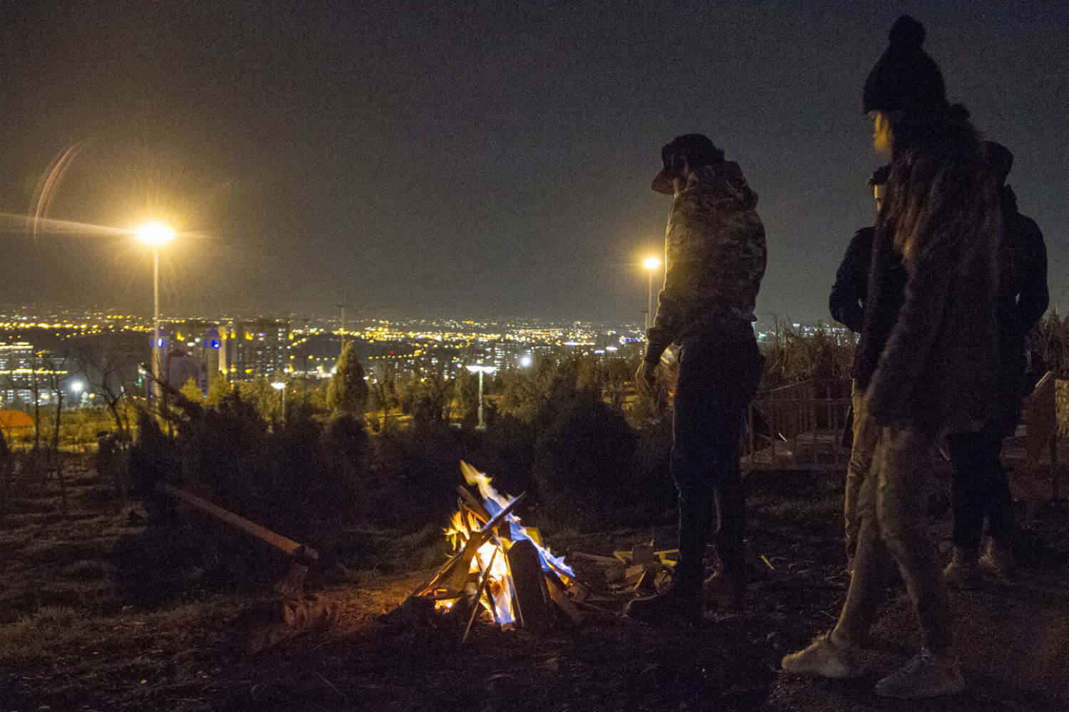 In the north-west in Abshar, at the foot of the mountains, small groups of young men and women hang around campfires near the Tehran Waterfall Park. (MEE)