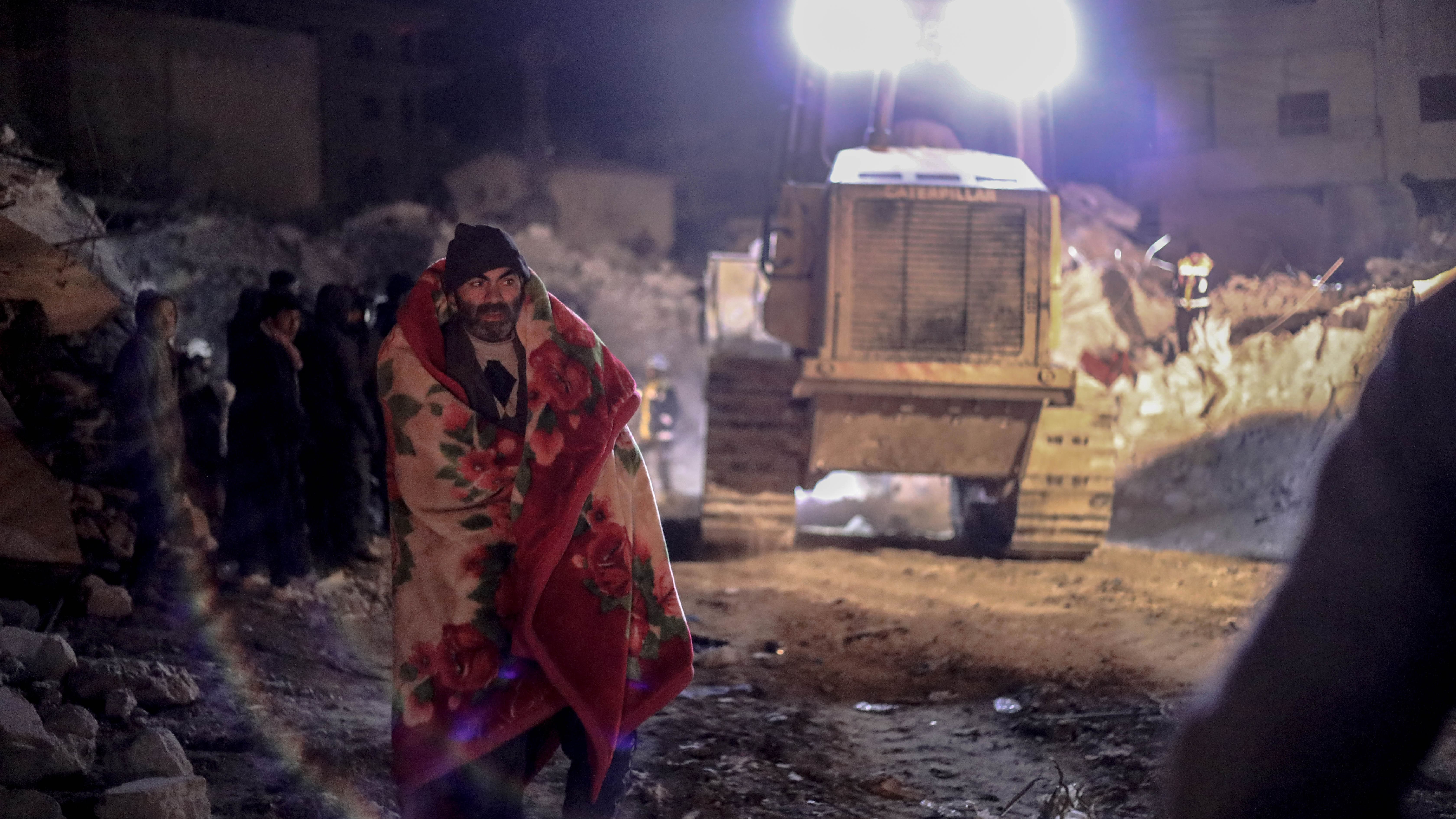Sami Jaqir walks back and forth as emergency workers try to rescue his family trapped under rubble (MEE/