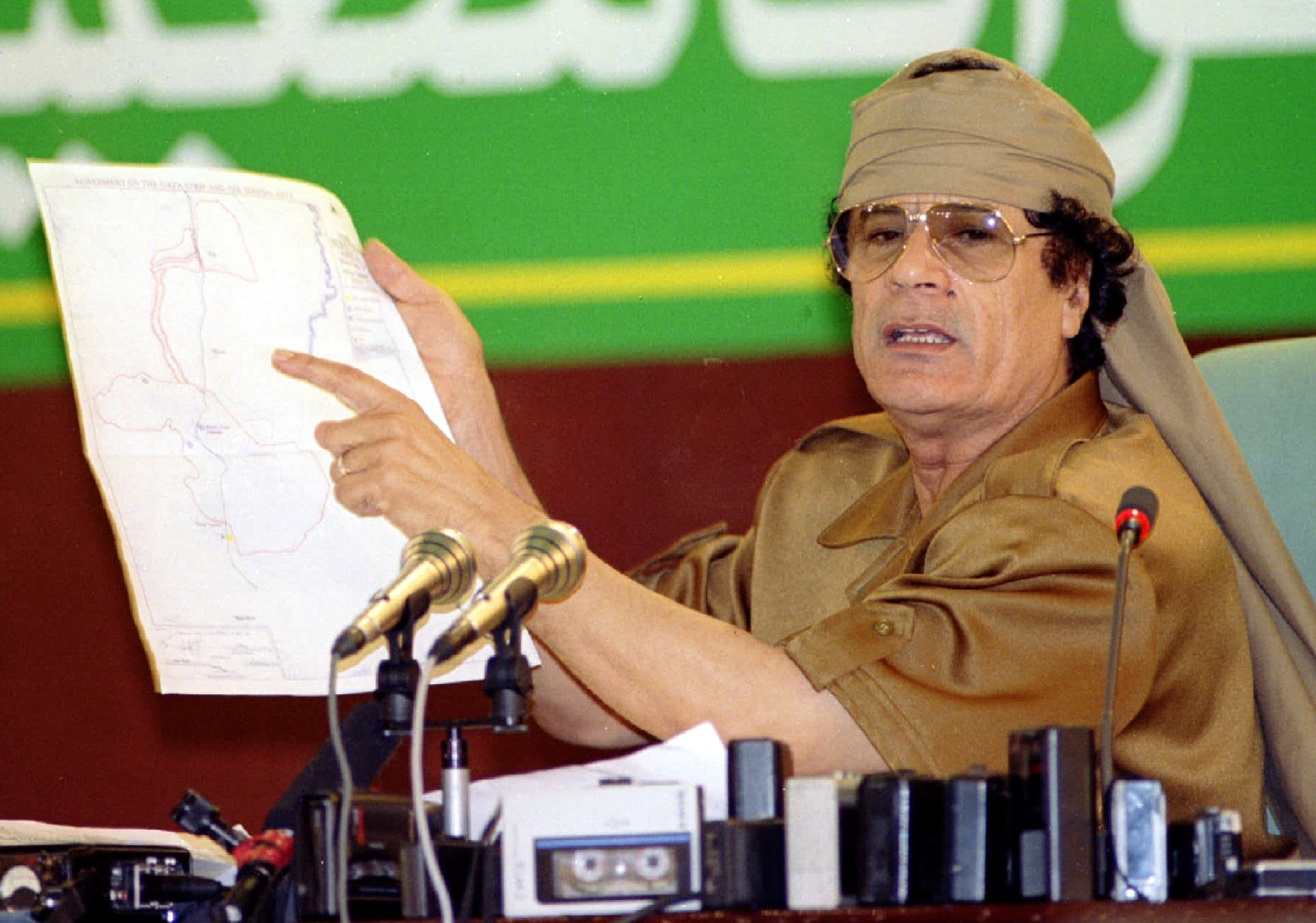 Libyan leader Muammar Gaddafi holds a map showing Israel in 1995 (Reuters)