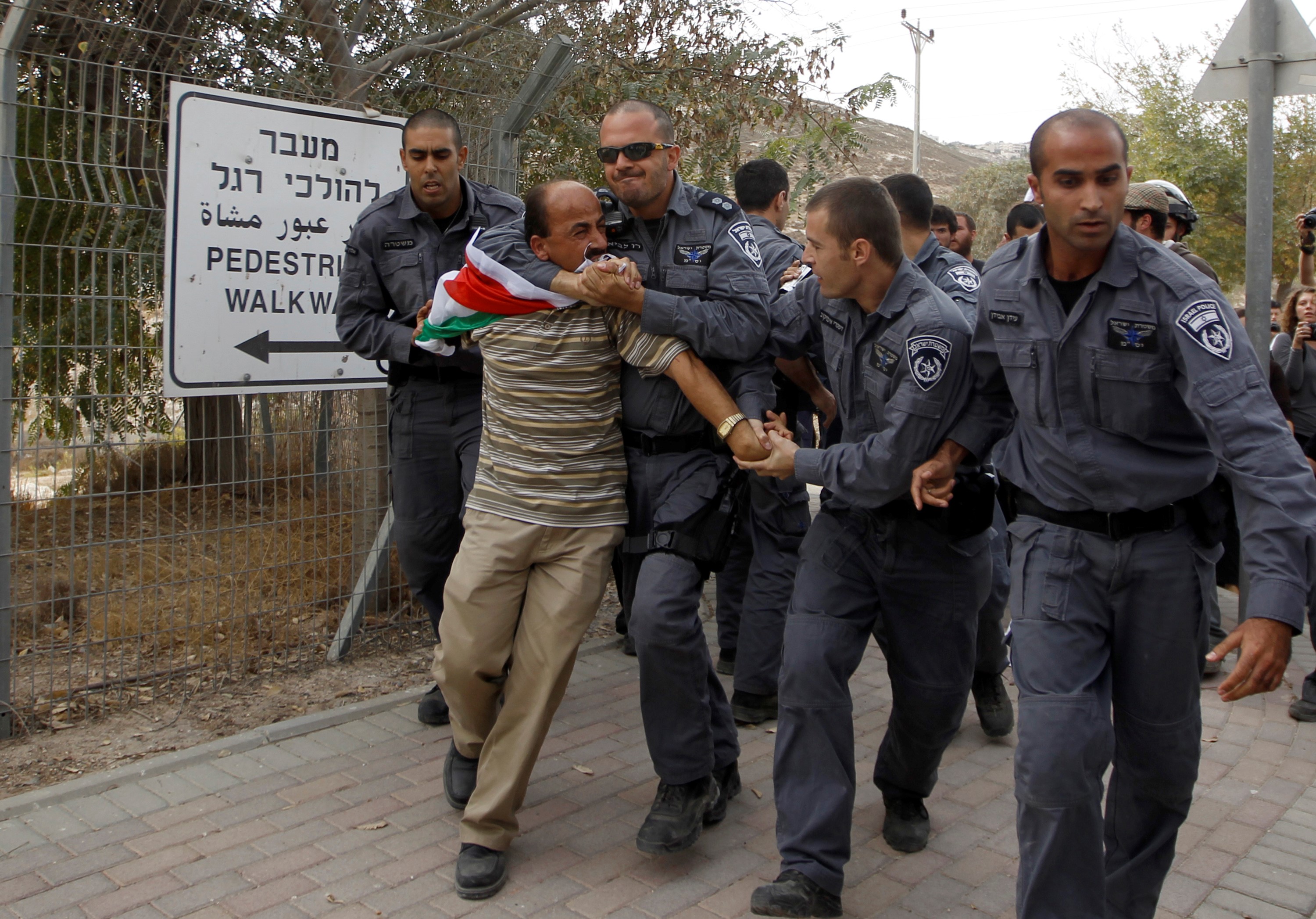 A Palestinian activist being detained by Israeli police during a protest against Jewish settlements (Reuters)
