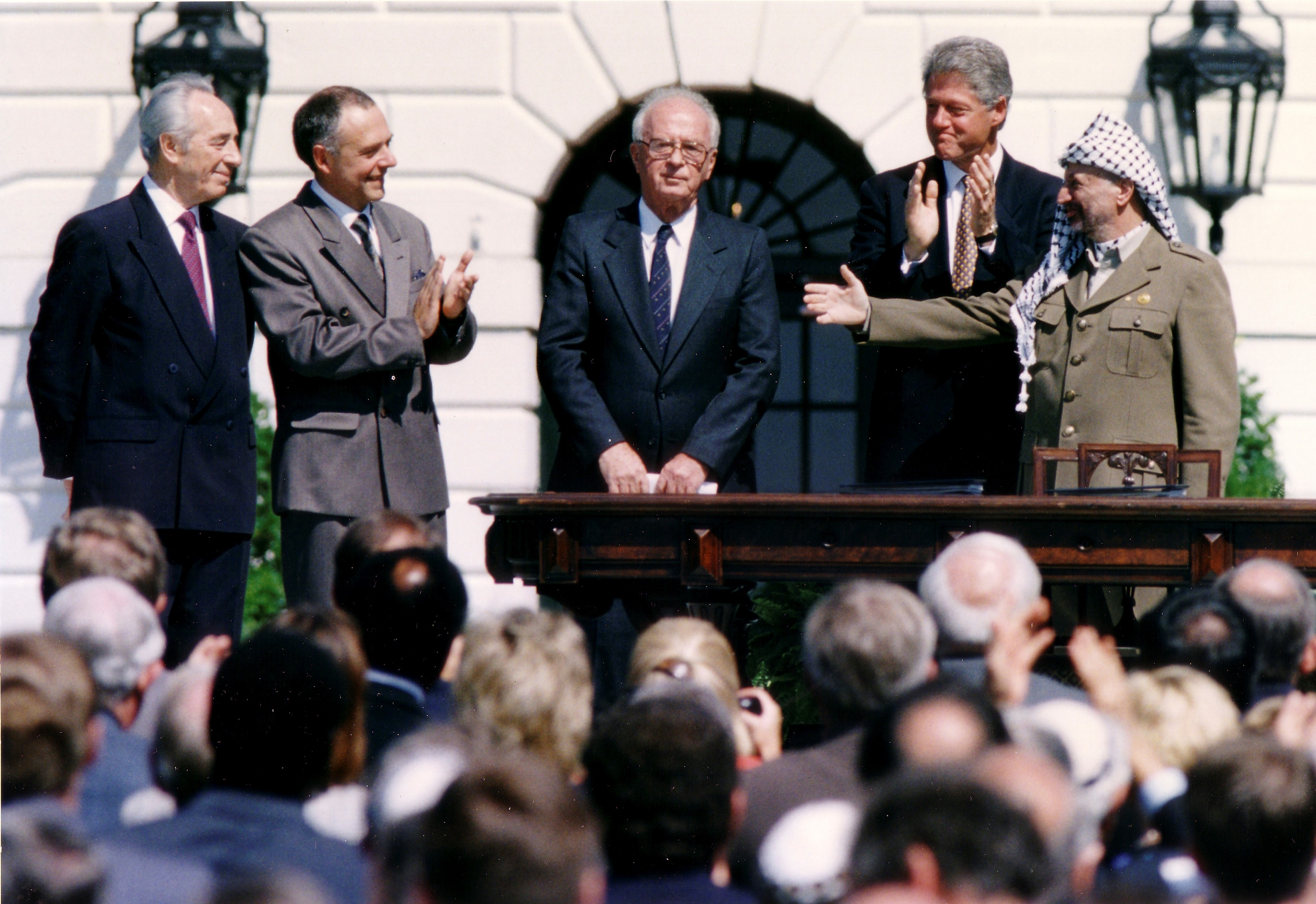   PLO Chairman Yasser Arafat (R) gestures to Israeli Prime Minister Yitzhak Rabin (3rd R), as US President Bill Clinton (2nd R) stands between them at the White House on 13 September, 1993 (Reuters)