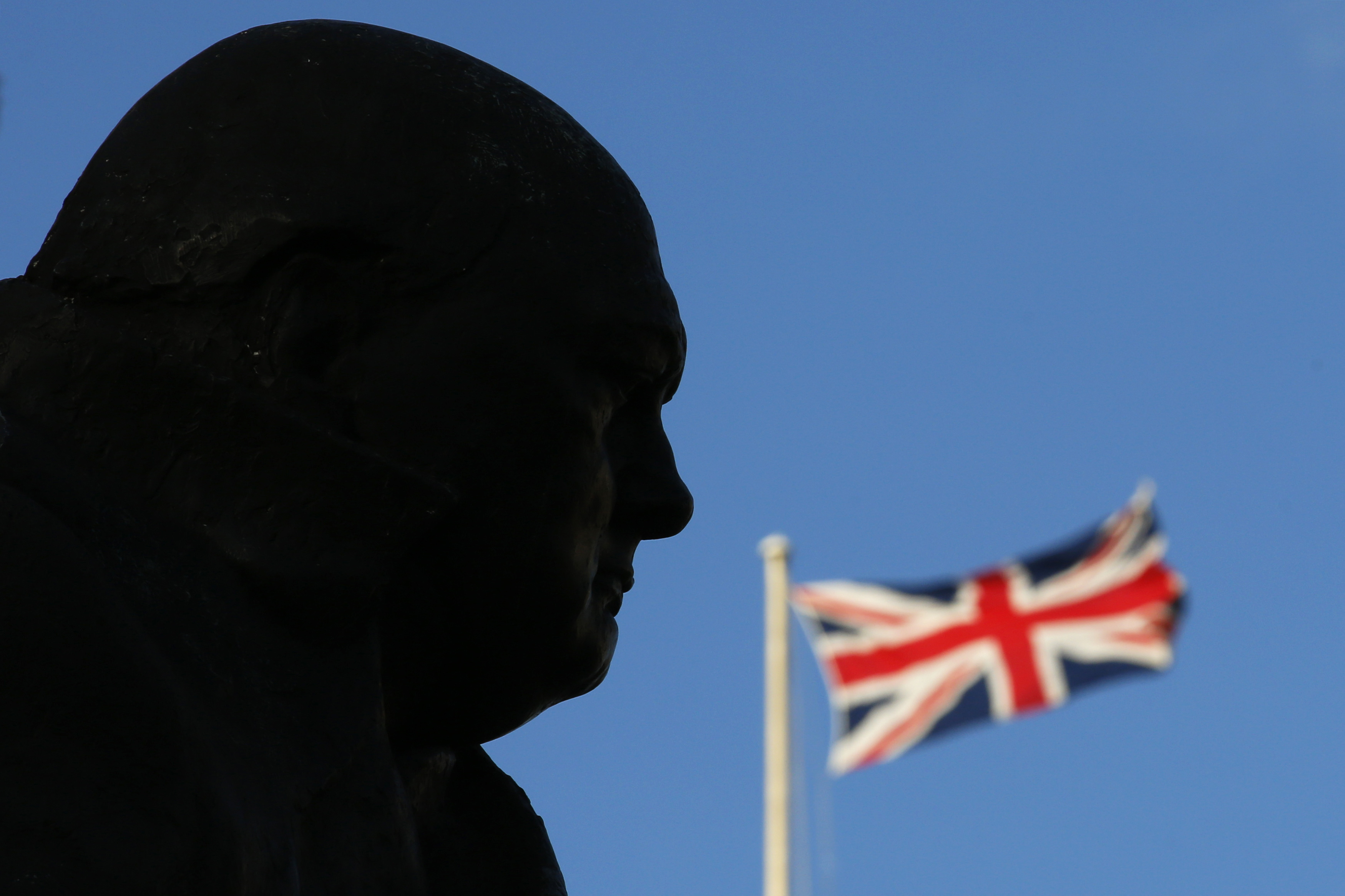 A Union Flag is seen behind a statue of Britain's former Prime Minister Winston Churchill in London 