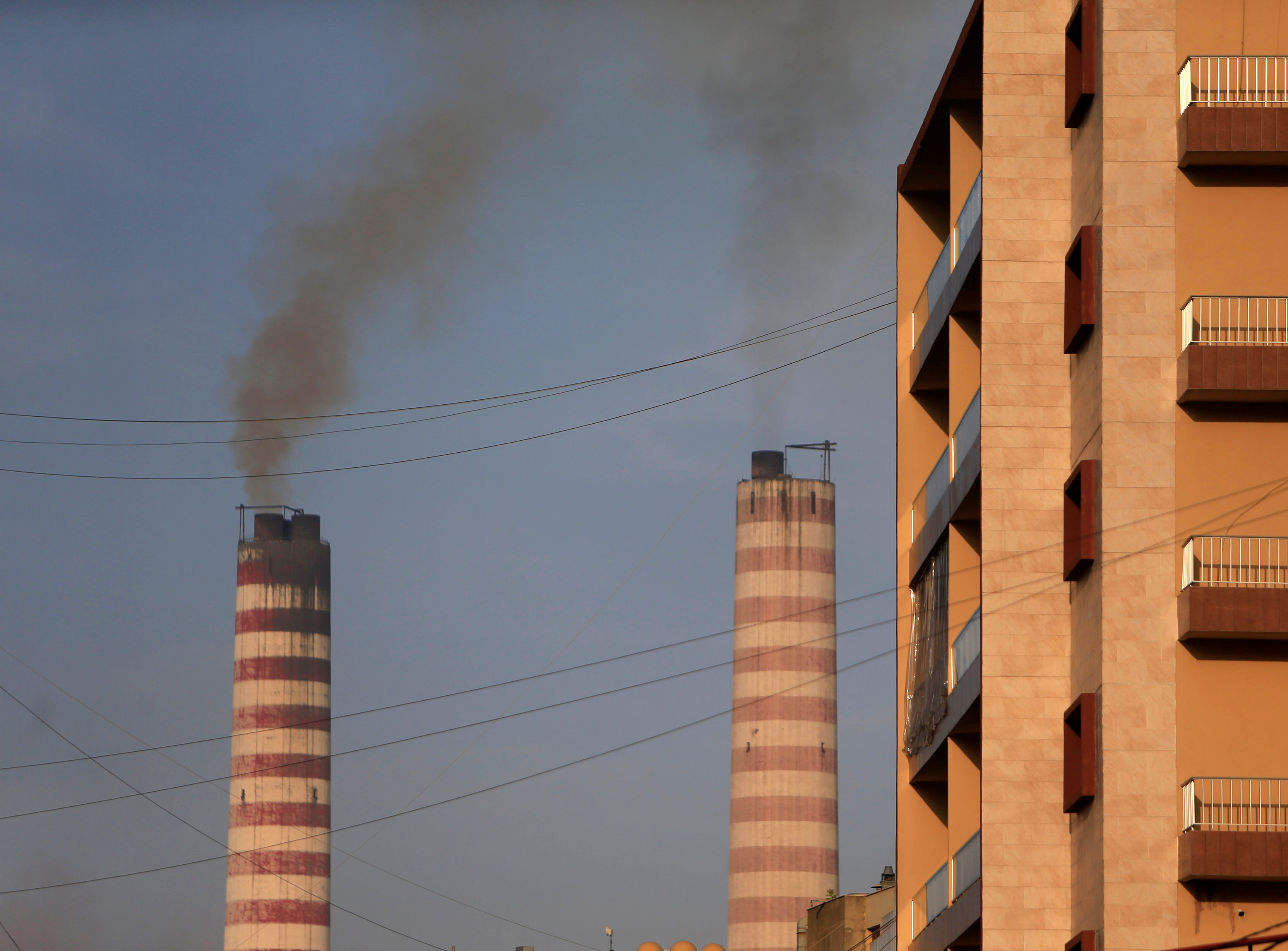 Smoke rises from a power plant near a residential building in Zouk area, north of Beirut (Reuters)
