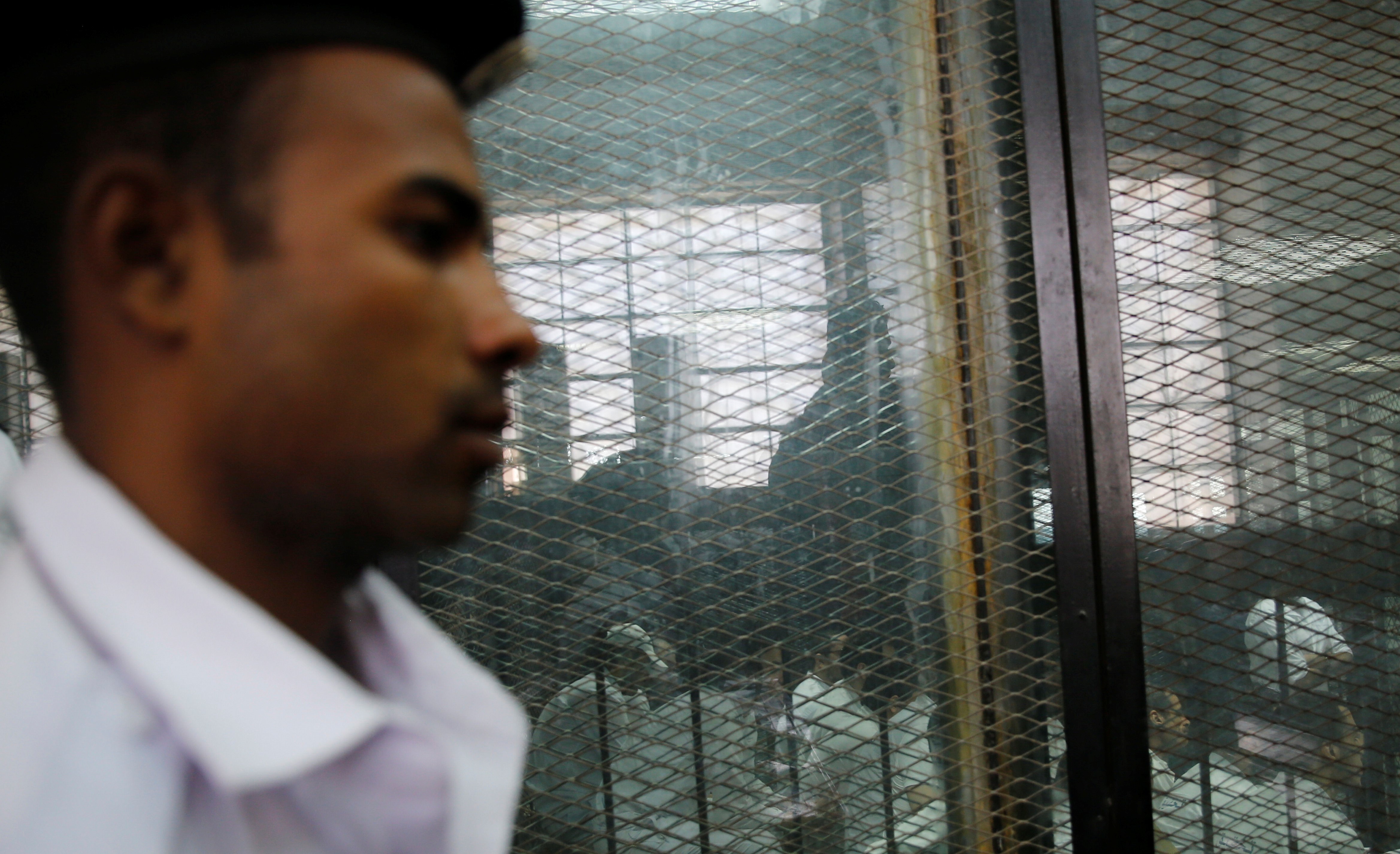 Un officier de police monte la garde devant des personnes accusées d’avoir participé en 2015 à l’assassinat du procureur général égyptien, le 17 juin 2015 (Reuters)