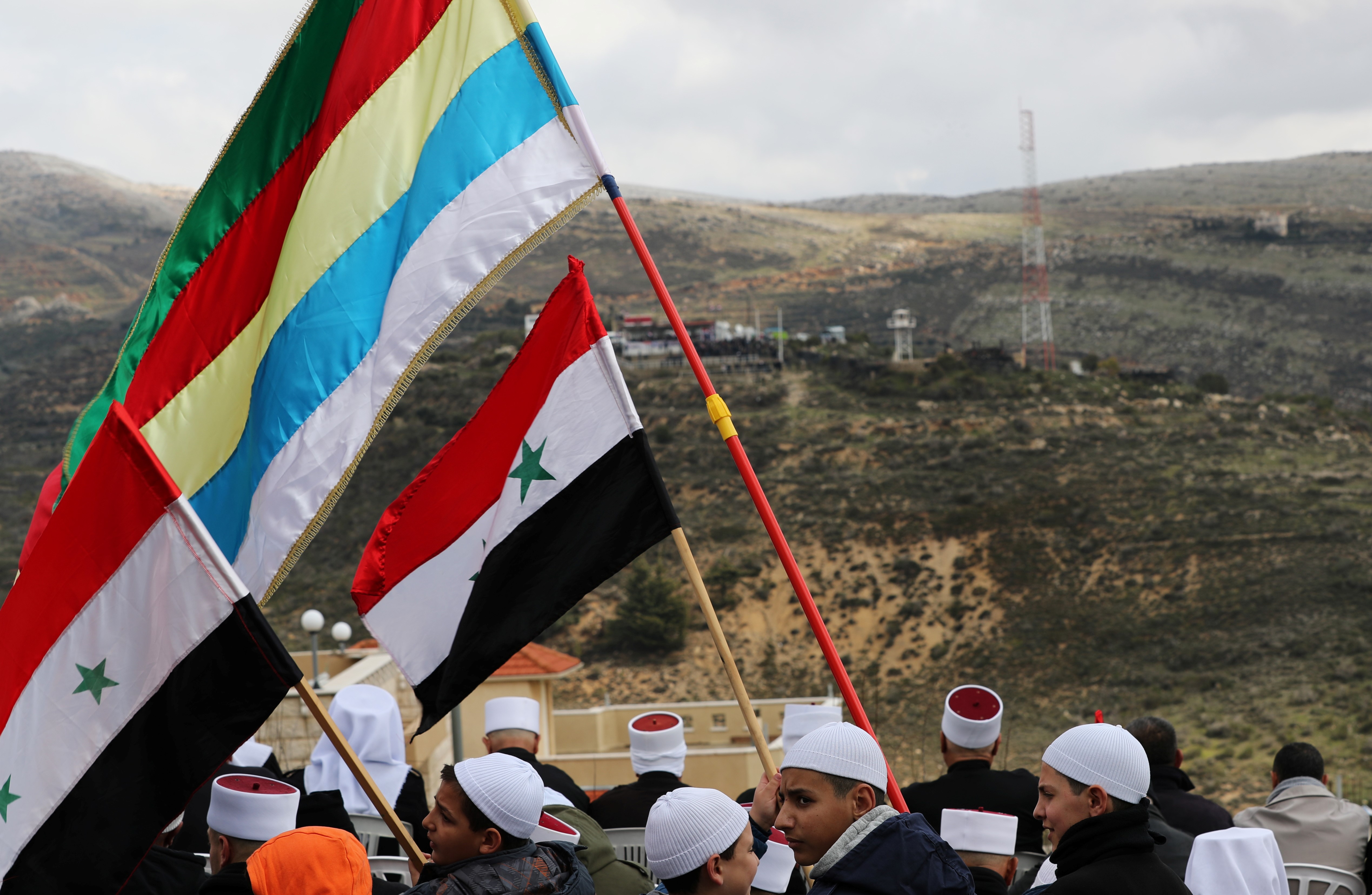 Members of the Druze community holds Syrian and Druze flags during a rally marking the anniversary of Israel's annexation of the Golan Heights on 14 February (REUTERS)