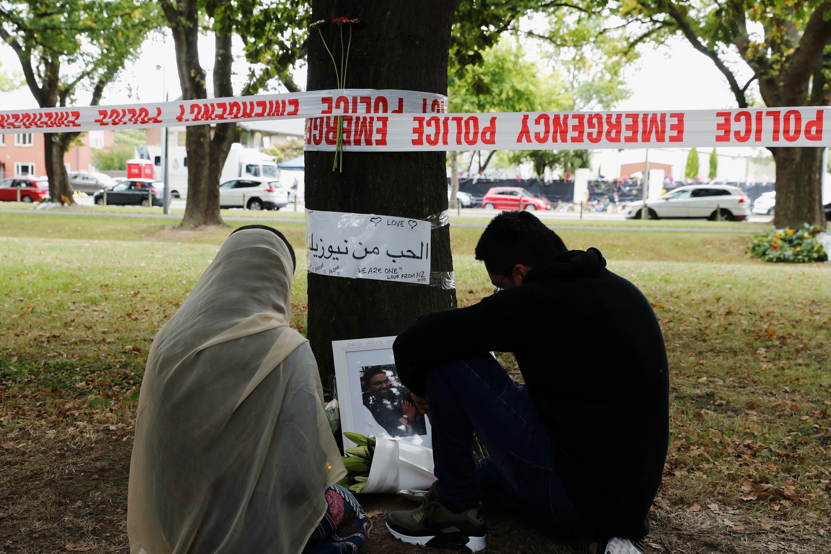 People visit at a memorial site for victims of Friday's shooting, in front of the Masjid Al Noor mosque in Christchurch, New Zealand on 18 March (REUTERS)