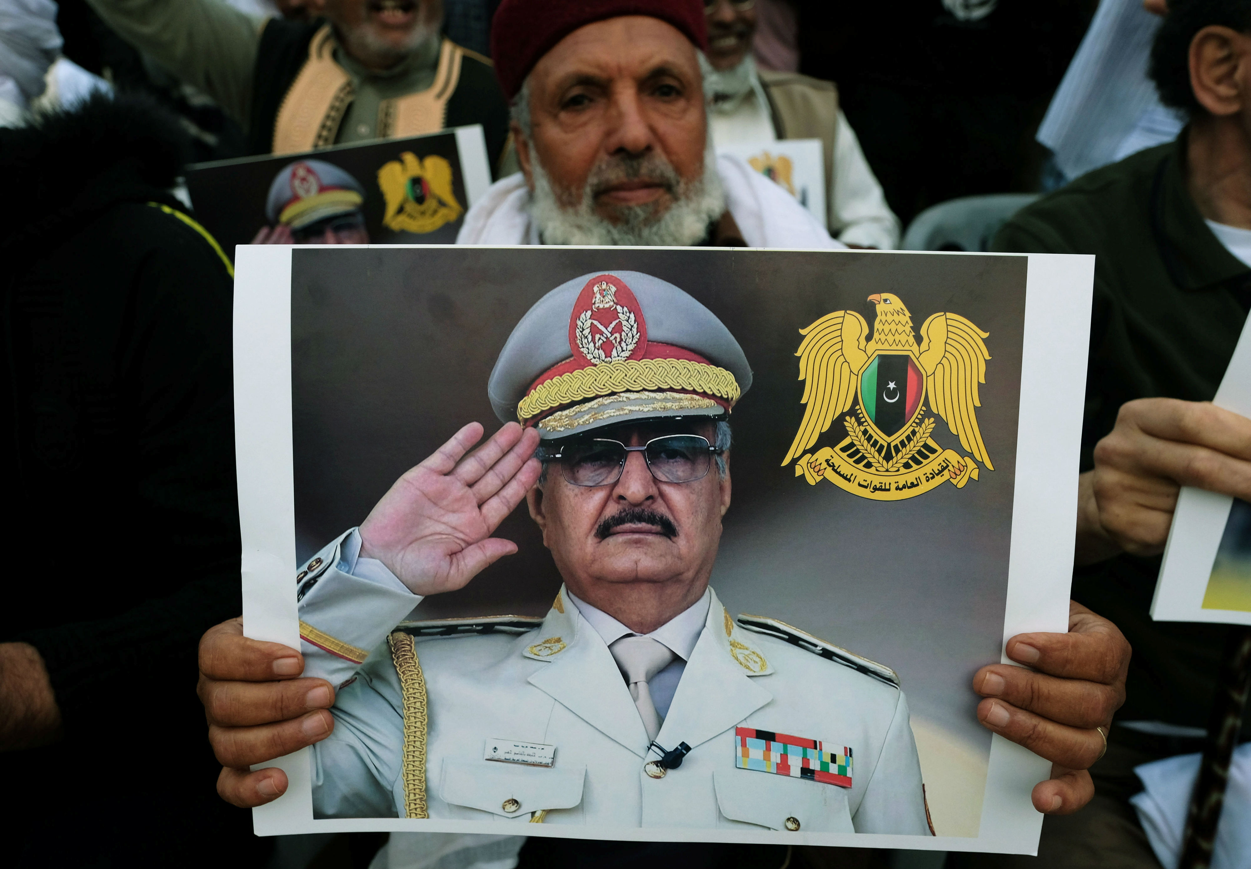 A Libyan man carries a picture of Khalifa Haftar during a demonstration to support Libyan National Army offensive against Tripoli, in Benghazi (Reuters)