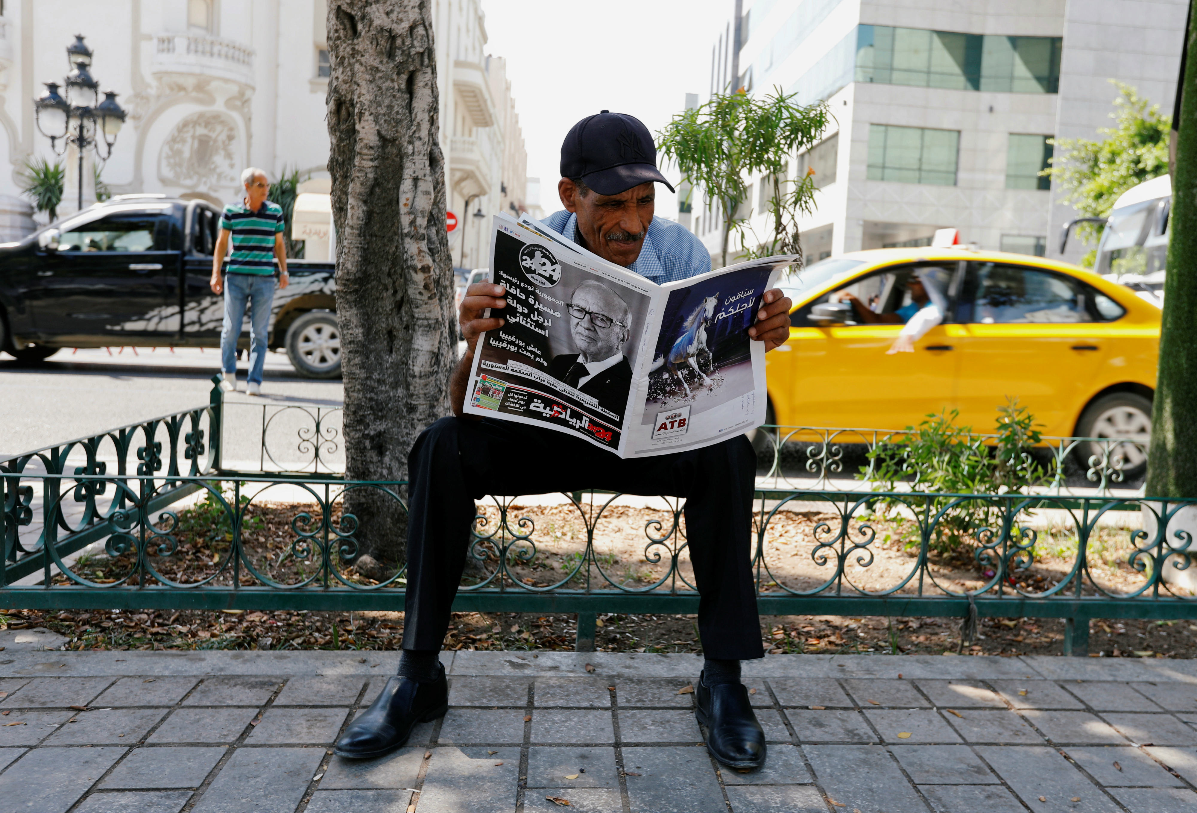 A man reads a local newspaper, displaying a picture of the late Tunisian President Beji Caid Essebsi in Tunis (Reuters)