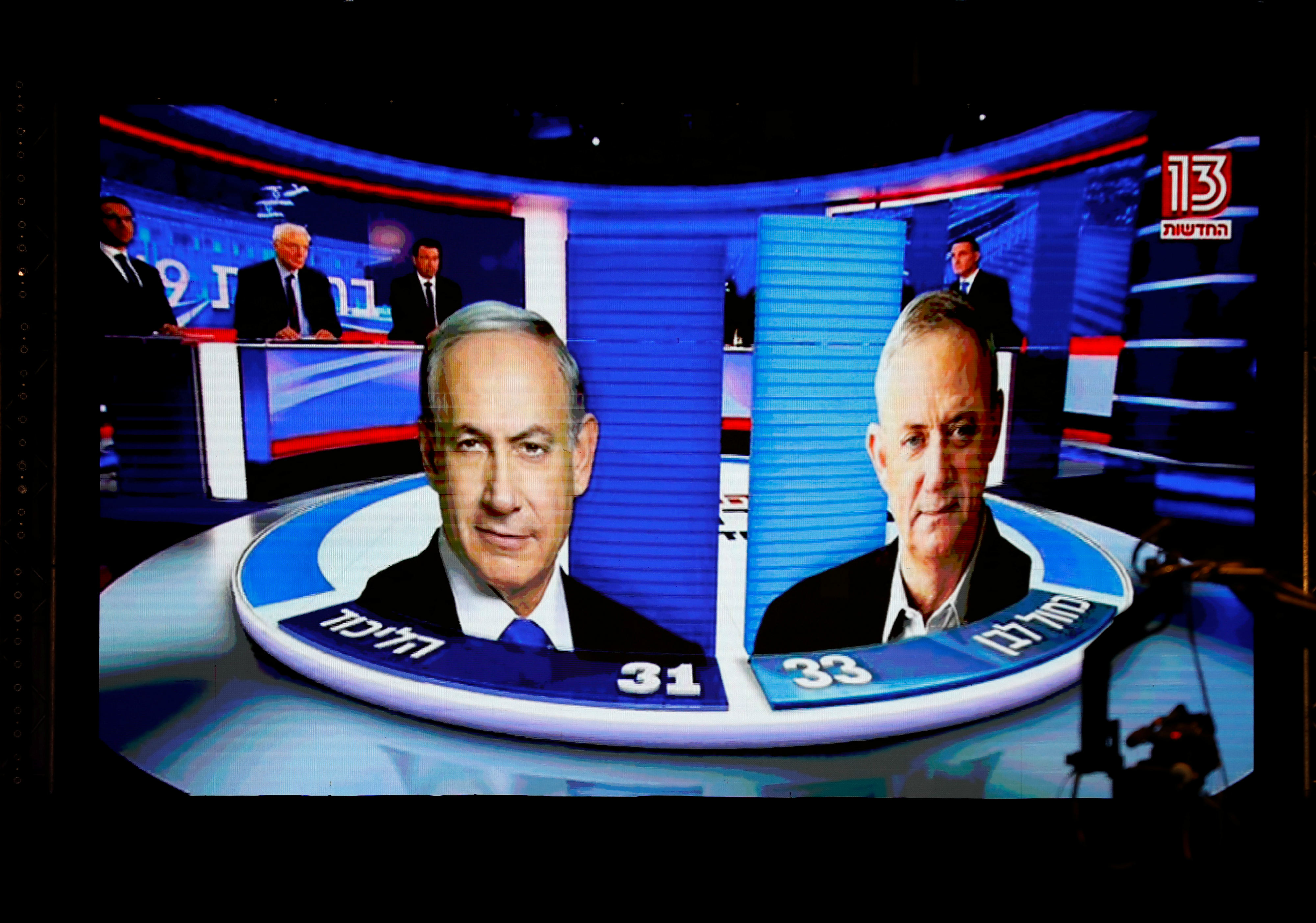 The results of the exit polls are shown on a screen at Benny Gantz's Blue and White party headquarters, following Israel's parliamentary election, in Tel Aviv (Reuters)