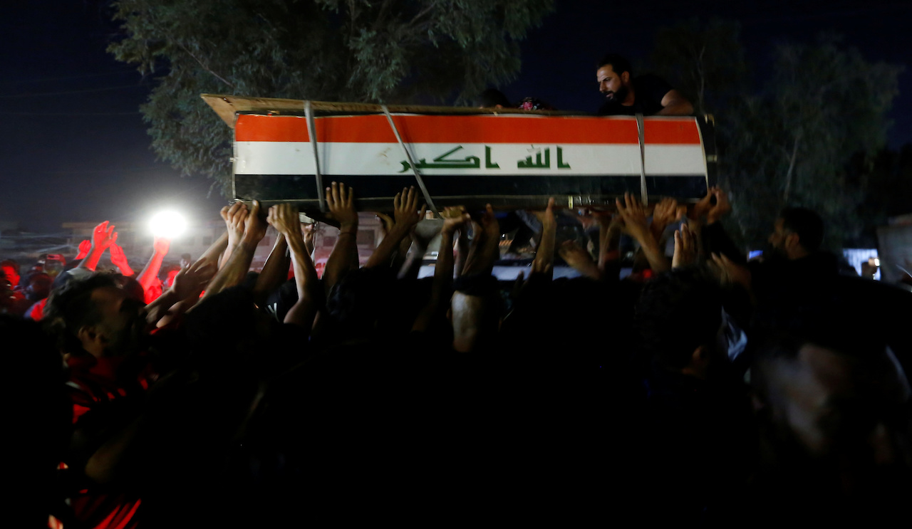 Men carry the coffin of a demonstrator who was killed during anti-government protests in Baghdad (Reuters)
