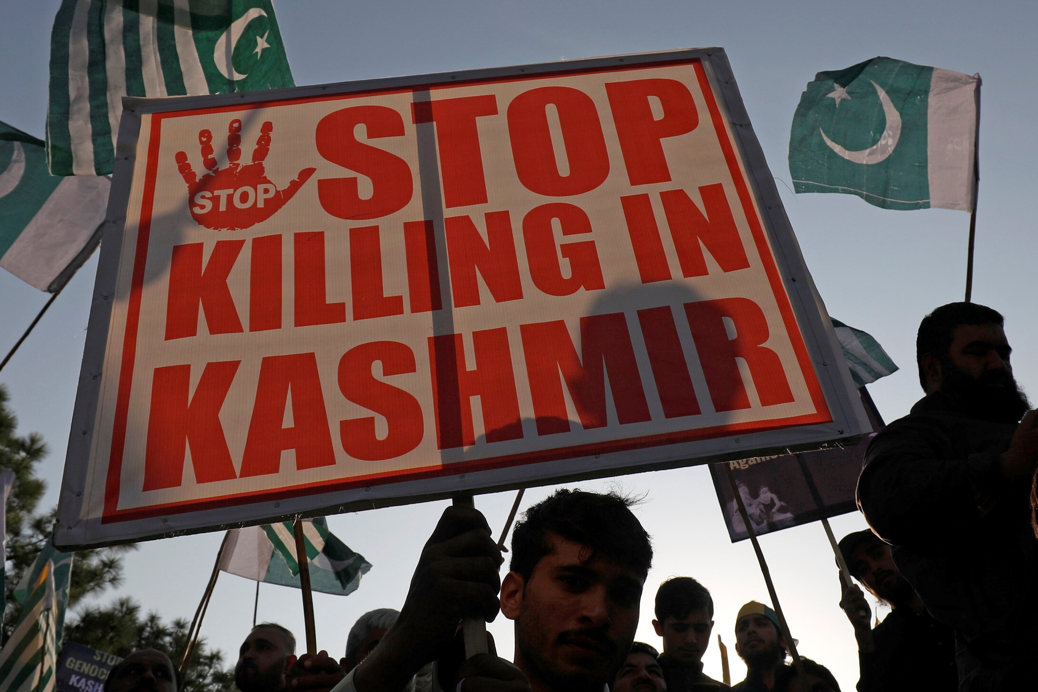  People carry Pakistan's and Azad Kashmir's flags and signs during what they call a freedom march in Islamabad, Pakistan on 20 October (Reuters)