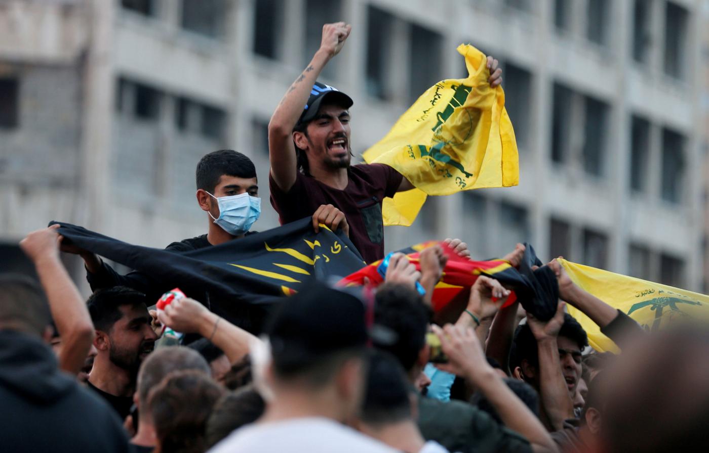 Des supporteurs du chef du Hezbollah libanais Hassan Nasrallah portent le drapeau du parti à Beyrouth (Reuters)
