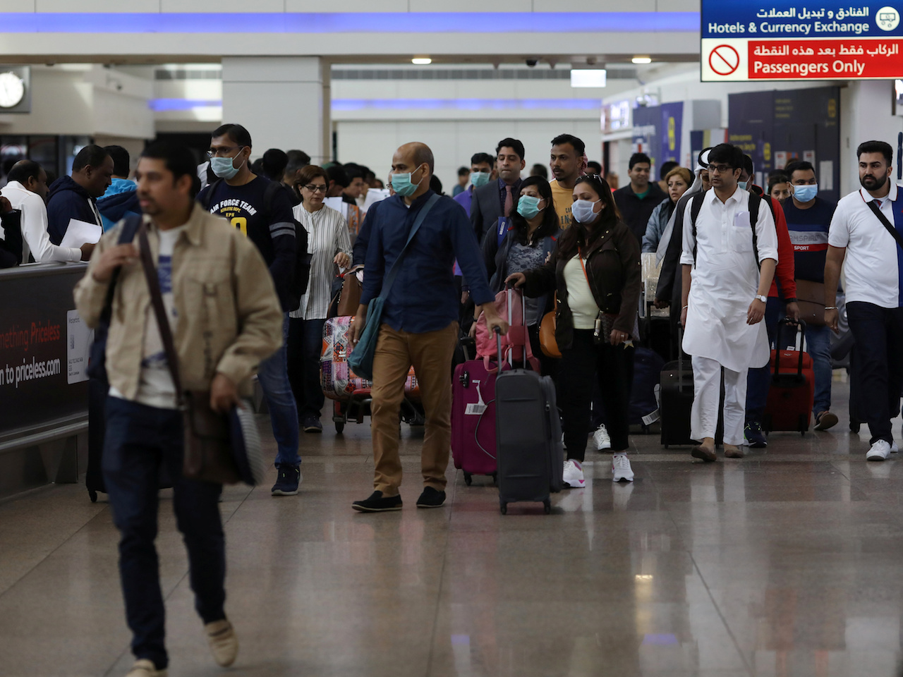 Travellers wear masks as they arrivw at the Dubai International Airport, after the UAE's Ministry of Health and Community Prevention confirmed the country's first case of coronavirus, in Dubai