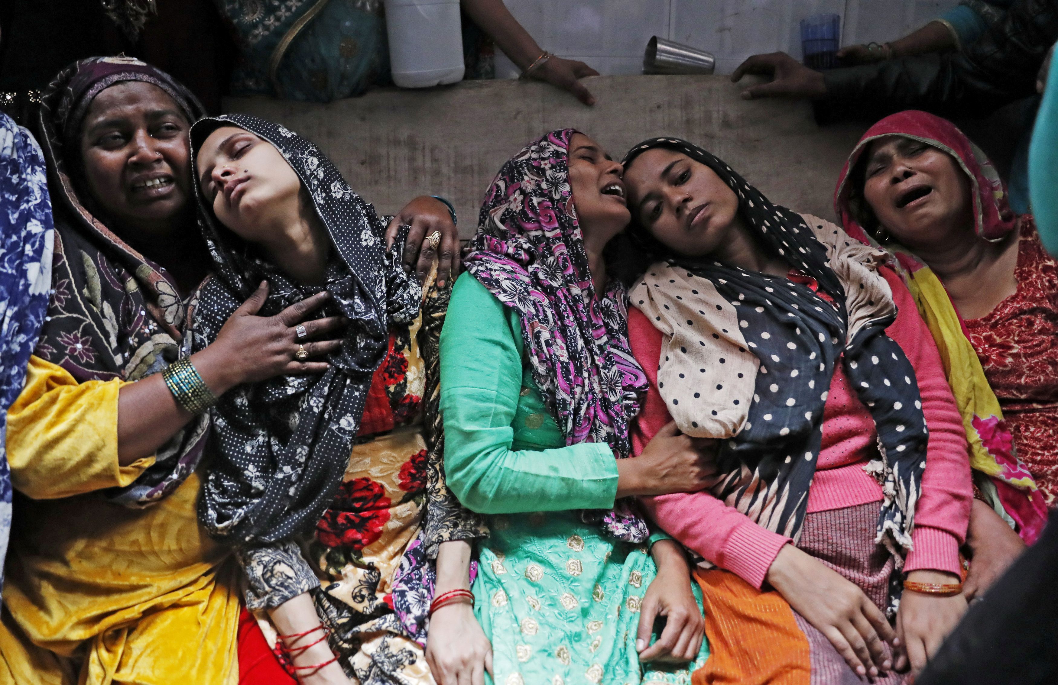   Relatives mourn next to the body of Hashim Ali who succumbed to his injuries, in a riot affected area in New Delhi, India, on 29 February 