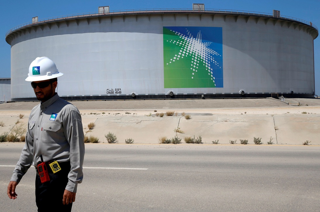 Un employé d’Aramco passe à côté d’un réservoir de pétrole dans la raffinerie de la compagnie pétrolière saoudienne à Ras Tanura (Reuters)