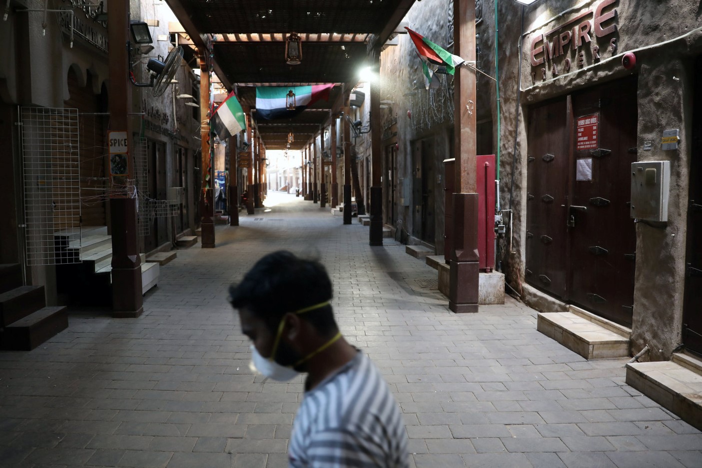 A man wearing a protective face mask walks through the deserted Barajeel Souq, following the outbreak of the coronavirus disease (COVID-19), in old Dubai, United Arab Emirates, March 31